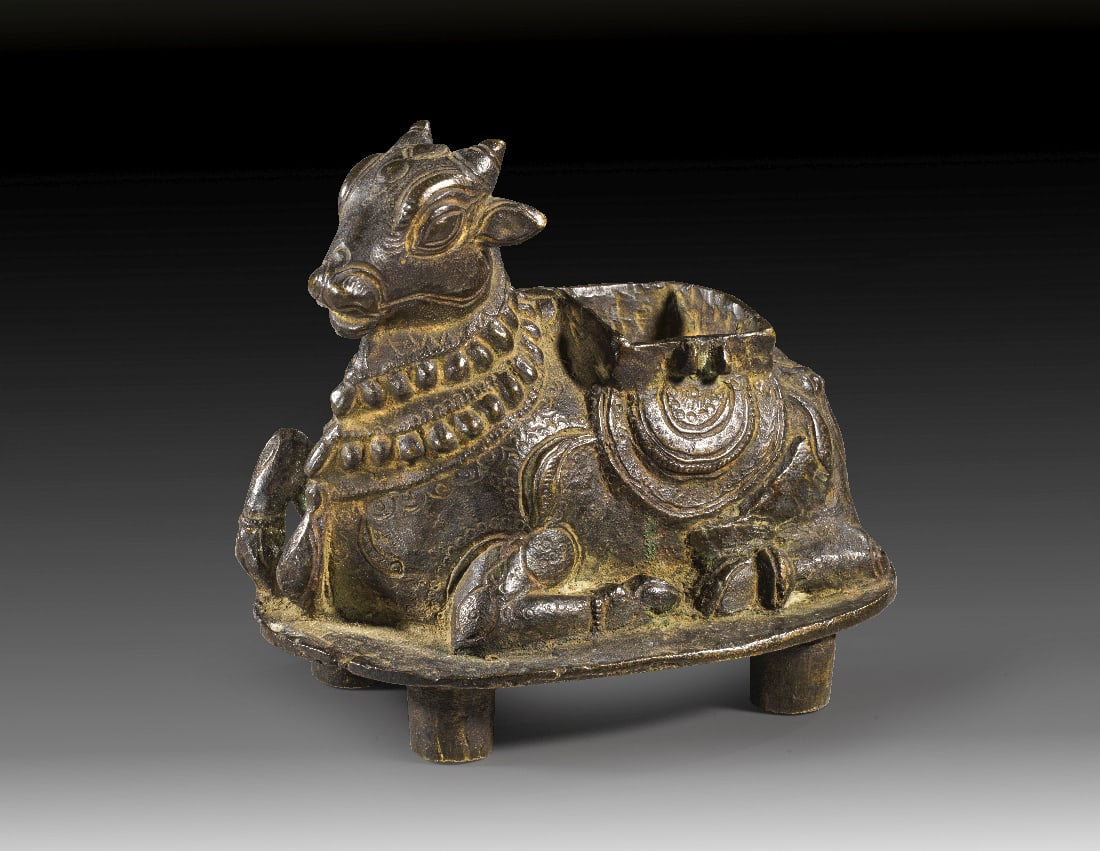 Reich ornamentierte Nandi-Bronze mit Opfermulde.: Reich ornamentierte Nandi-Bronze mit Opfermulde. Indien, wohl Suedindien (Tamil Nadu oder Karnataka), 15. Jh. H 11,5cm, B 13cm. Gelbgussbronze im Hohlguss mit nachtraeglicher Kaltbearbeitung.
