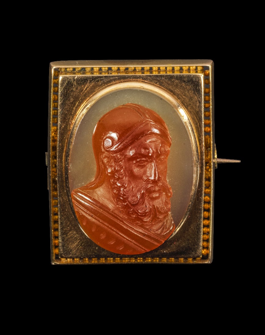 Goldbrosche mit Achat-Kameo.: Goldbrosche mit Achat-Kameo. 19. Jh. 9,98g, 2,8 x 2,3cm. Hochovaler, zweischichtiger Achat-Kameo mit der behelmten Bueste eines Kriegers. Gefasst in einer rechteckigen Brosche aus Gelbgold.