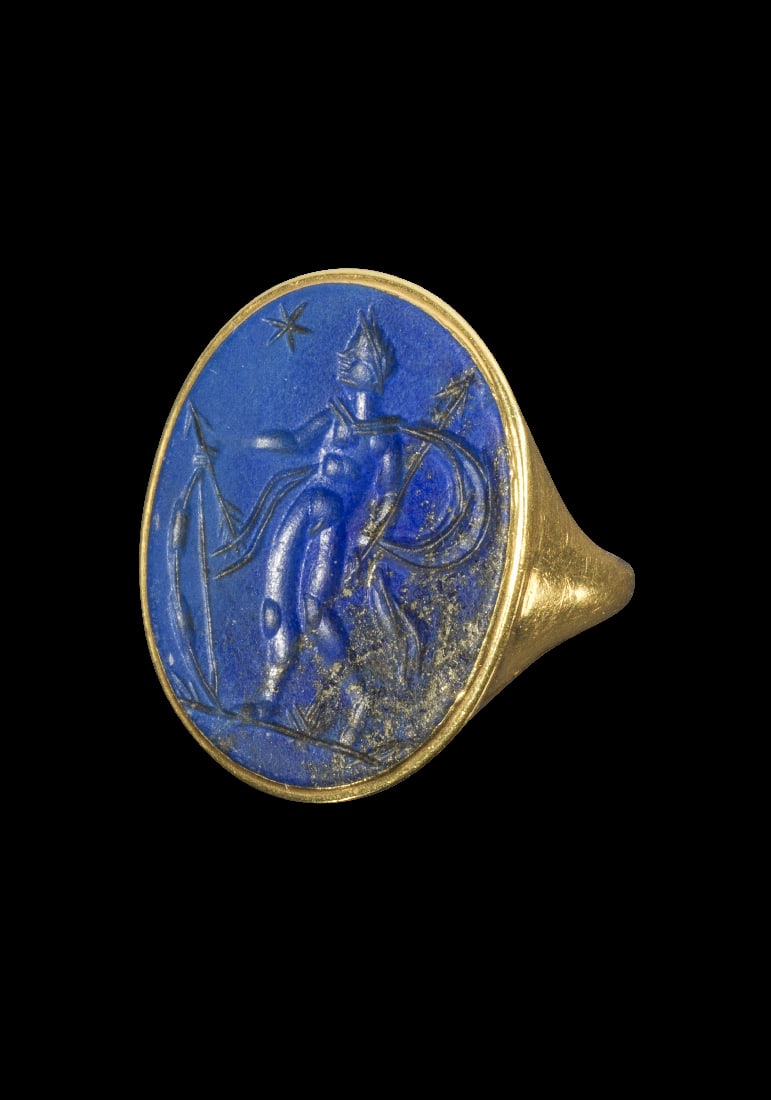 Gelbgoldring mit Gemme aus Lapislazuli.: Gelbgoldring mit Gemme aus Lapislazuli. Gemme: 19. Jh. 8,95 g. Ringgroesse 50. Schmale, nach oben breiter werdende, nach aussen konvexe Schiene, auf der Platte eingelassen eine laengsovale Gemme aus b