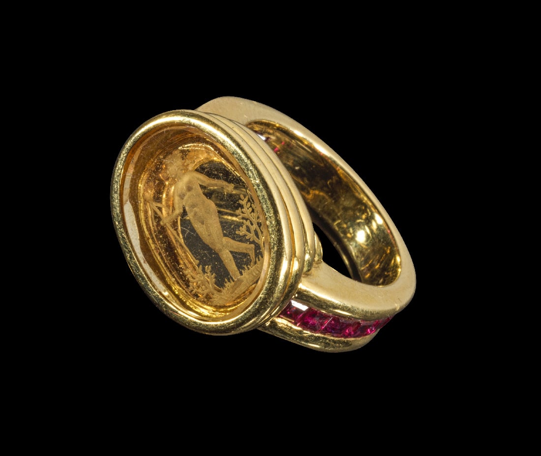 Goldring mit Rubinen und Glasgemme.: Goldring mit Rubinen und Glasgemme. Europa, 20. Jh. 11,65g, Ringgroesse 52. Hochovaler Intaglio aus Glas, graviert mit einer Muse, die einen Thyrsos in der Hand haelt, zwischen Straeuchern. Auf der Sc