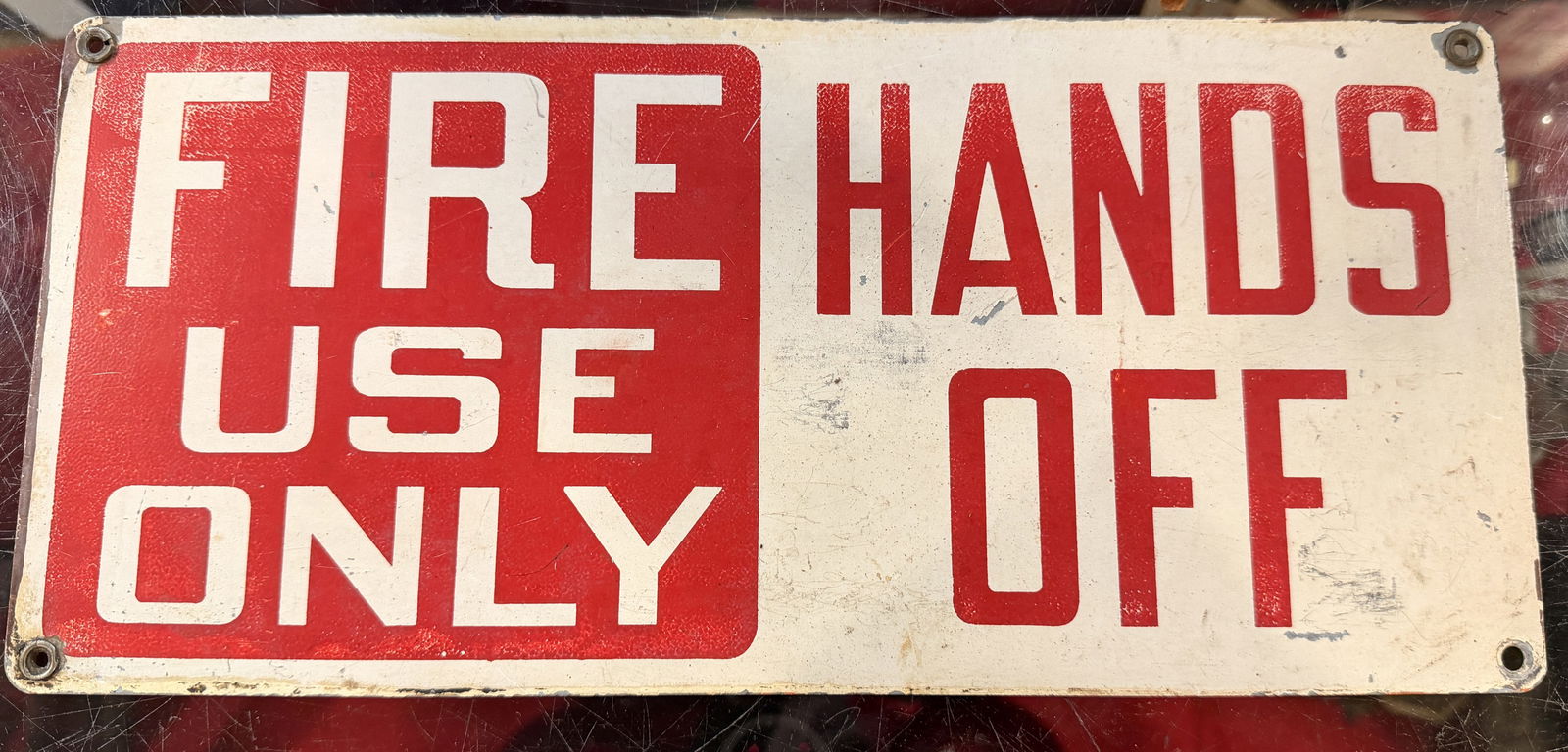 Painted Metal Industrial Warning Sign, 'FIRE USE ONLY / HANDS OFF': A rectangular industrial warning sign, likely constructed from painted or enameled metal. The design is divided, with the left half featuring "FIRE USE ONLY" in white sans-serif block letters on a