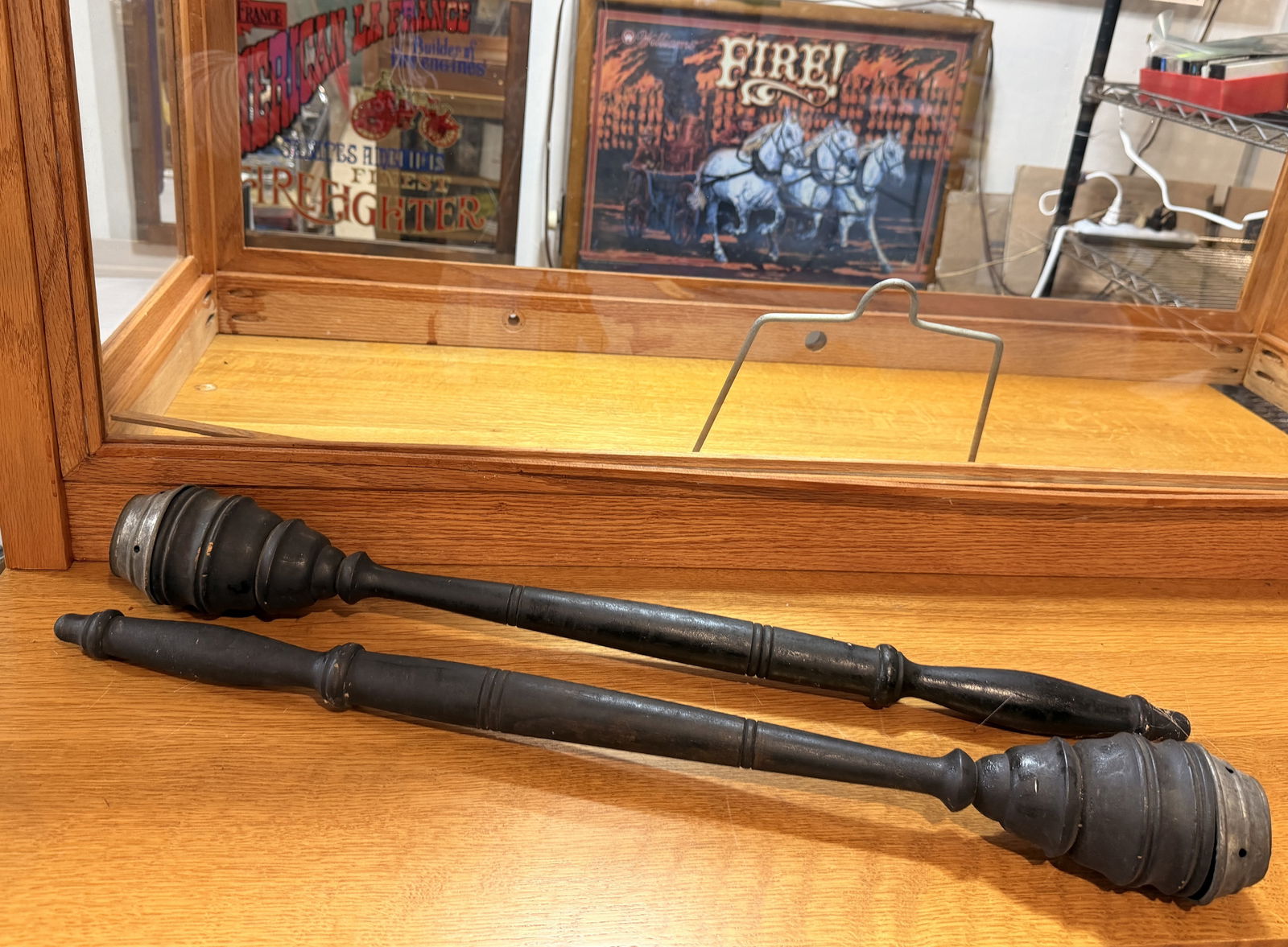 A Pair of Fire Parade Torches: A pair of late 19th-century firefighting parade torches. Each object is crafted from dark-stained or painted turned wood, featuring a ribbed, bulbous head capped in unpolished metal.