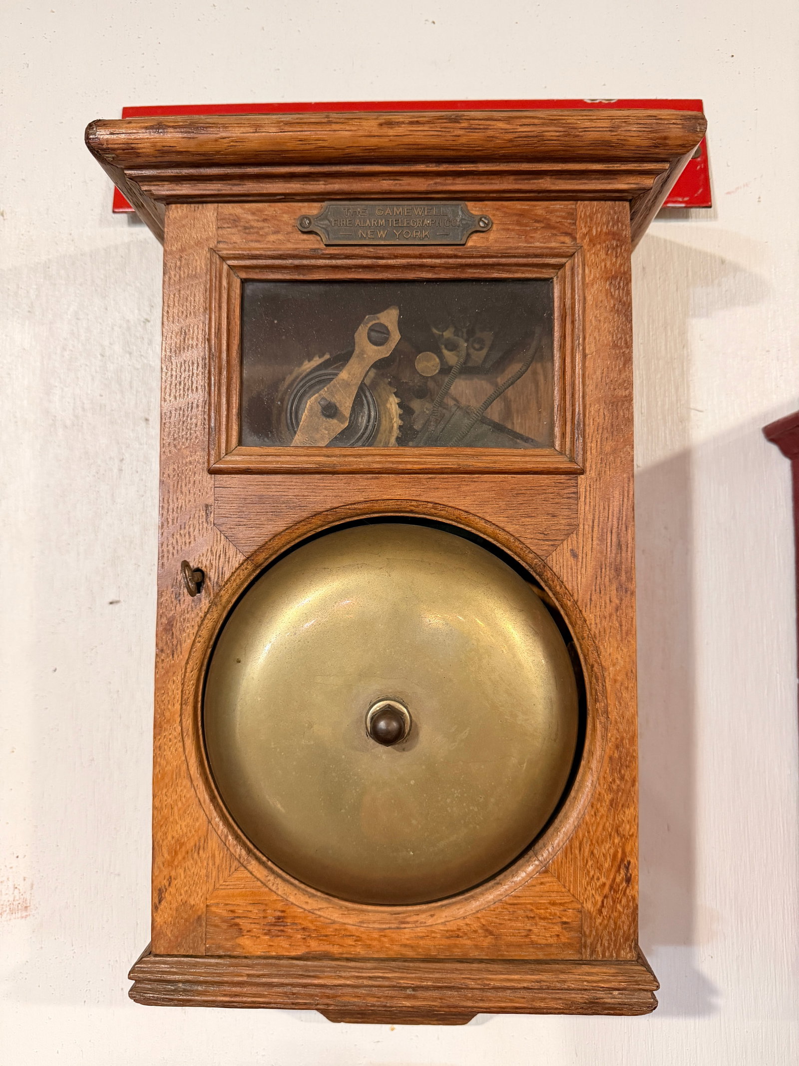 A Gamewell Fire Alarm Telegraph Co. Oak Cased Fire Gong, Late 19th/Early 20th Century: A wall-mounted Gong / fire alarm telegraph register by The Gamewell Fire Alarm Telegraph Co., dating from the late 19th to early 20th century. The register is encased in a rectangular, dark-stained