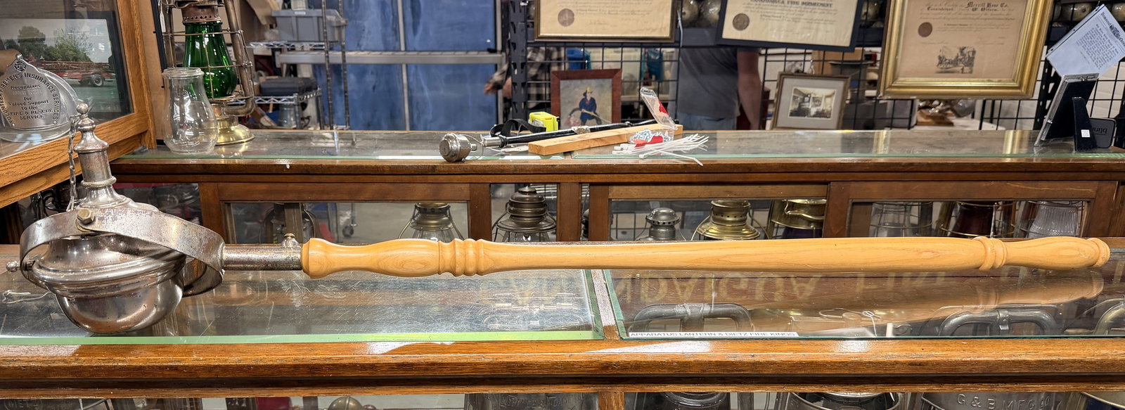 Antique Firefighters Parade Torch: A Double Swivel Head antique firefighters parade torch, featuring a spherical silver-toned metal head, a attached to a turned wooden handle. The head, likely constructed from nickel-plated brass or st
