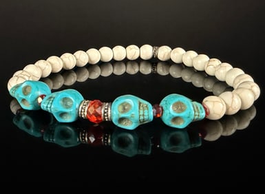 Silver and Beaded Stretch Bracelet Featuring Turquoise-Colored Skull Motifs