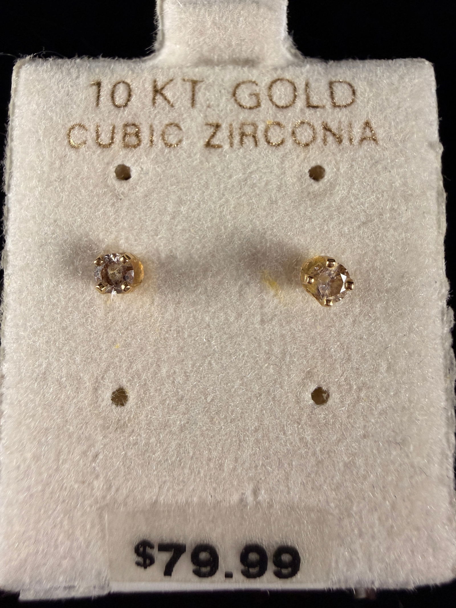 A Pair of 10K Yellow Gold and Cubic Zirconia Stud Earrings: A pair of yellow gold stud earrings featuring round-cut cubic zirconia stones. Each earring is constructed with a classic four-prong setting and is accompanied by a matching butterfly back. The earrin