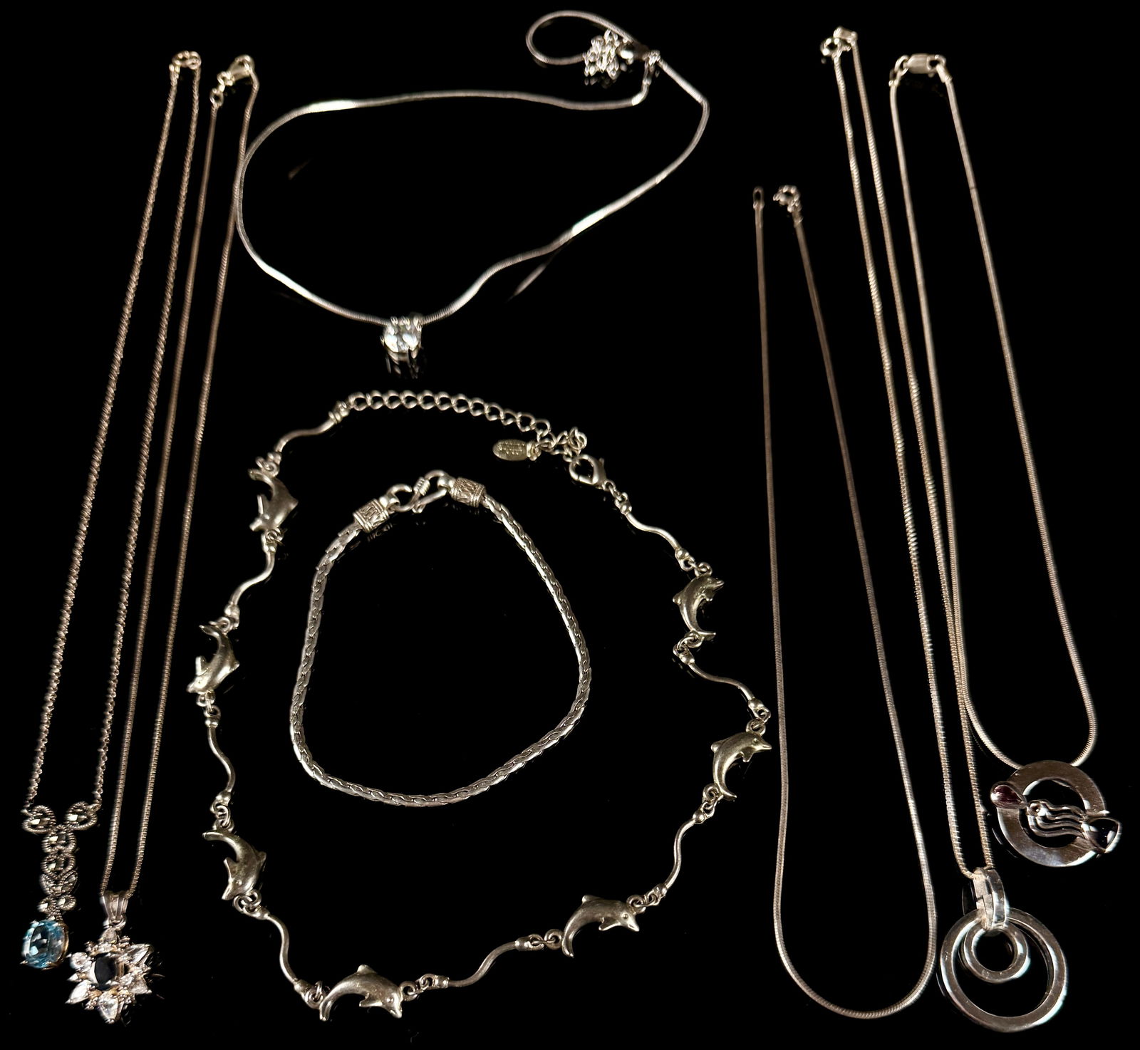 A Collection of Sterling Silver Jewelry: A collection of sterling silver jewelry consisting of various necklaces and bracelets in contemporary styles. The assortment features multiple chain constructions, including snake and link styles. Dec