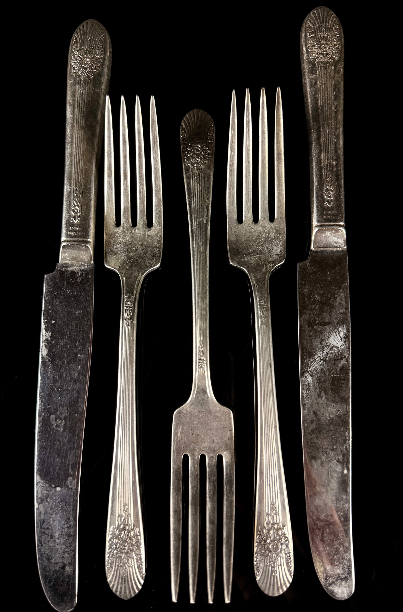 4.5 ozt Sterling Silver Flatware: A collection of sterling silver flatware in the Century pattern. The design features a stylized floral cluster with radiating reeded lines and a scalloped terminal. The group consists of dinner knives