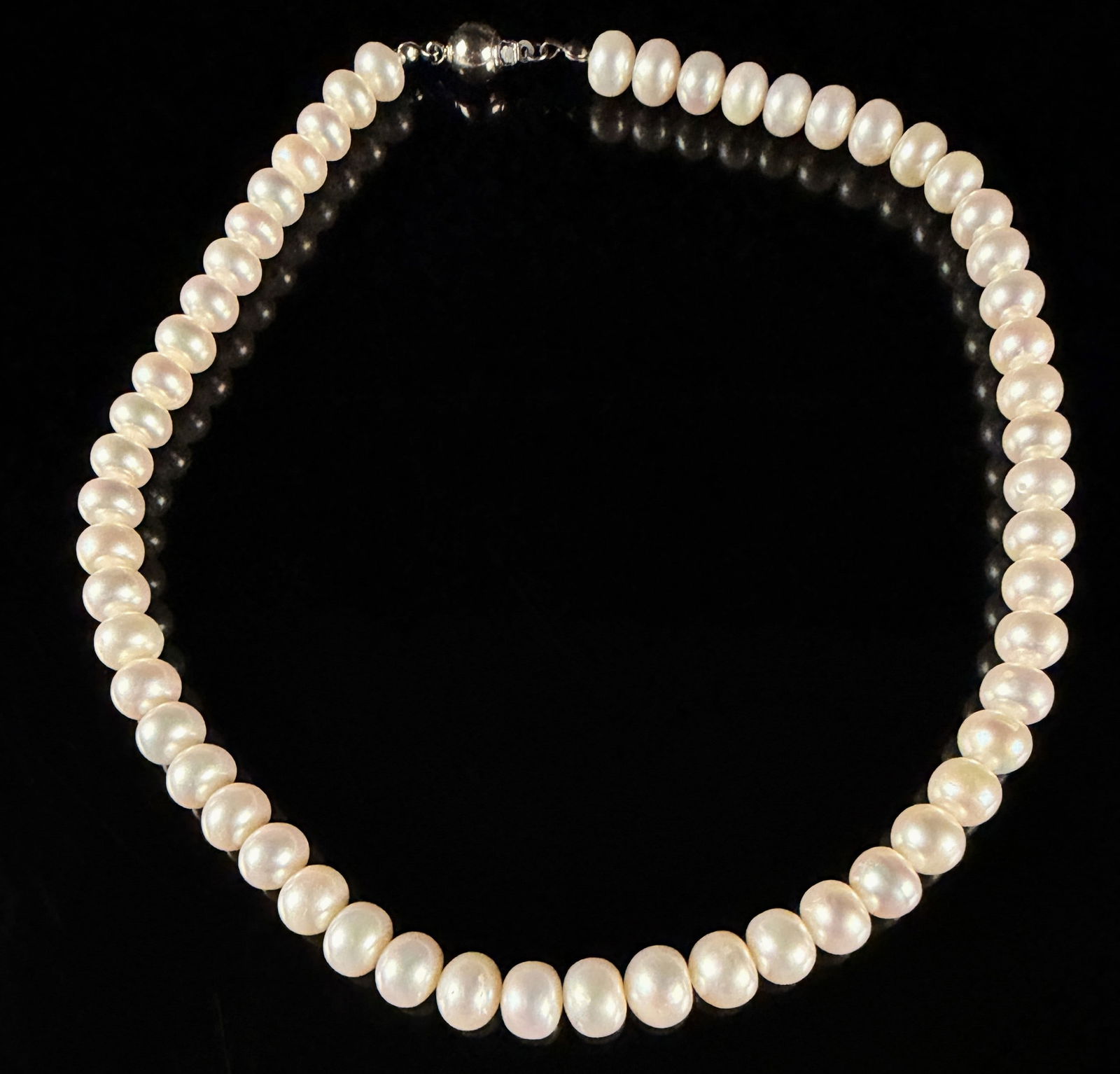 A Single-Strand Freshwater Cultured Pearl Necklace with Silver-Tone Clasp: This single-strand necklace is composed of freshwater cultured pearls featuring a creamy white body color and high luster. The pearls are near-round in shape and exhibit minor natural surface variatio