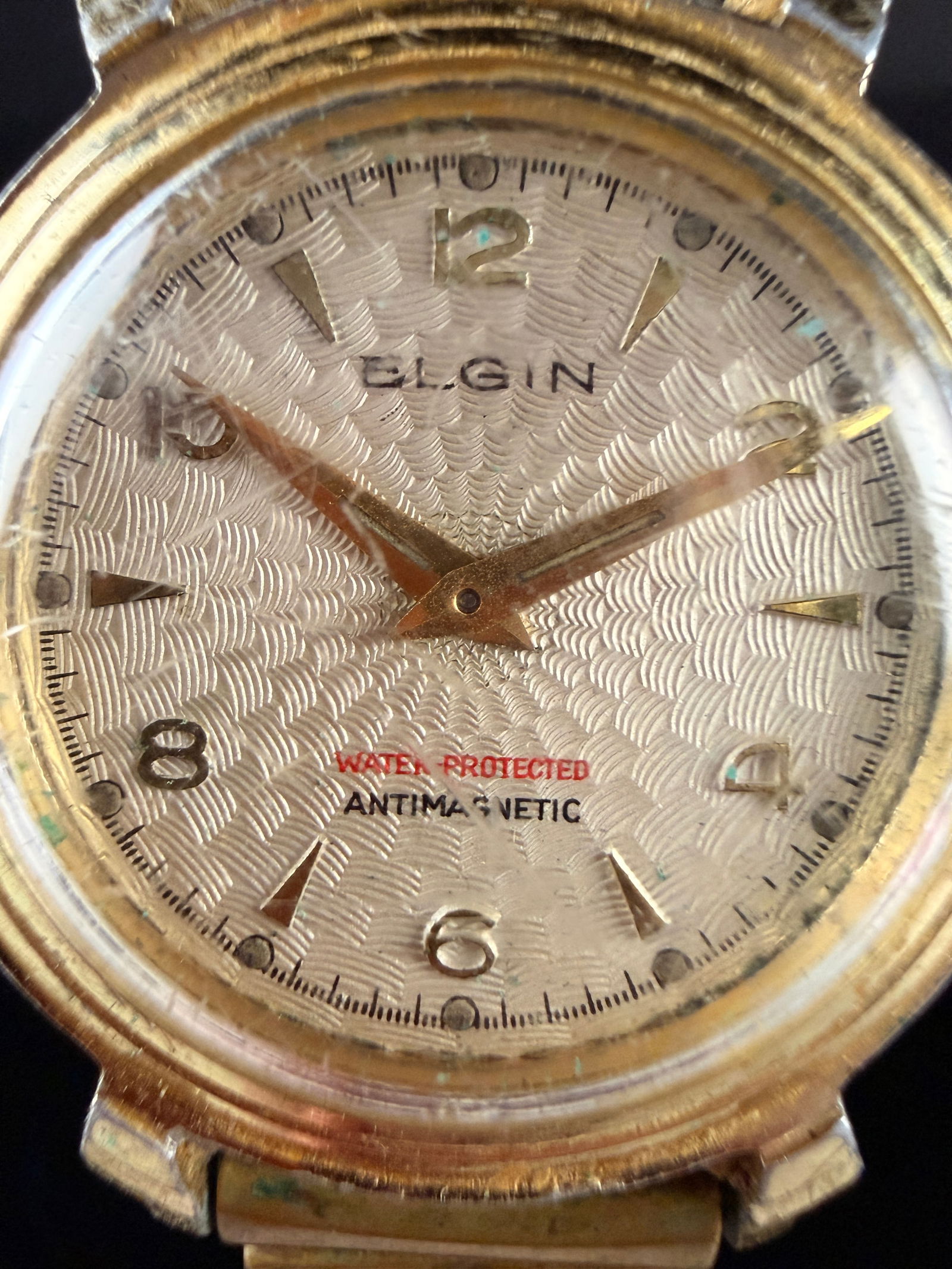 Vintage Elgin Self-Winding Gold-Toned Men's Wristwatch: Runs but needs a good servicing and cleaning. This Elgin self-winding wristwatch features a gold-toned case and a textured silver-tone dial. The dial is marked with the maker name ELGIN, WATER