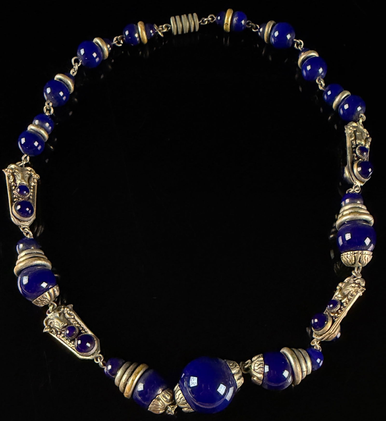Rams Head Czechoslovakian Cobalt Blue Glass and Silver-Tone Metal Necklace: An Art Deco style necklace featuring a graduated collection of translucent cobalt blue glass beads. The necklace is constructed with silver-tone metal components, including decorative bead caps,