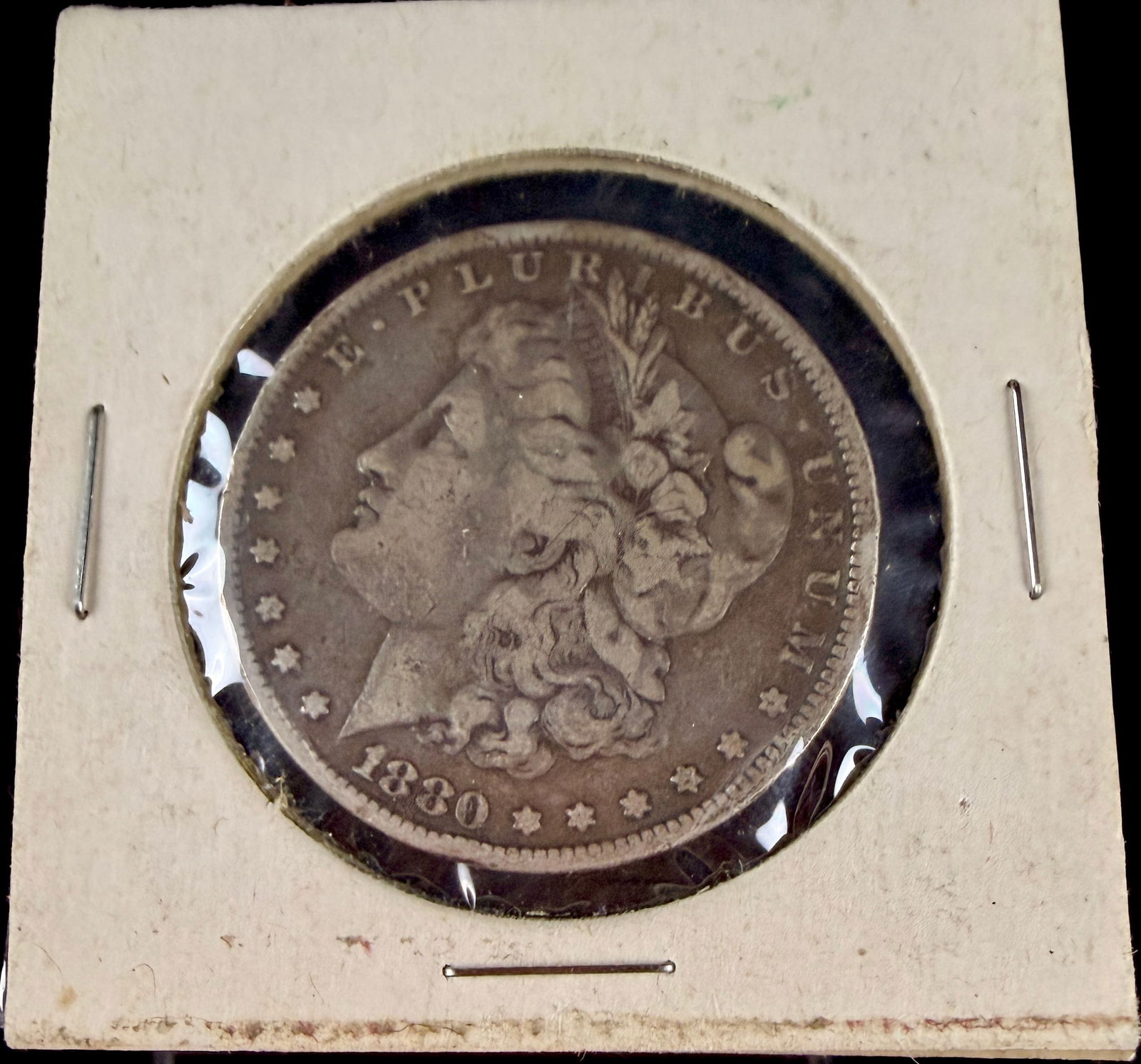 1880 United States Morgan Silver Dollar: This 1880 United States Morgan Silver Dollar was struck at the Philadelphia Mint. The obverse features the George T. Morgan design of a left-facing profile of Lady Liberty wearing a Phrygian cap adorn