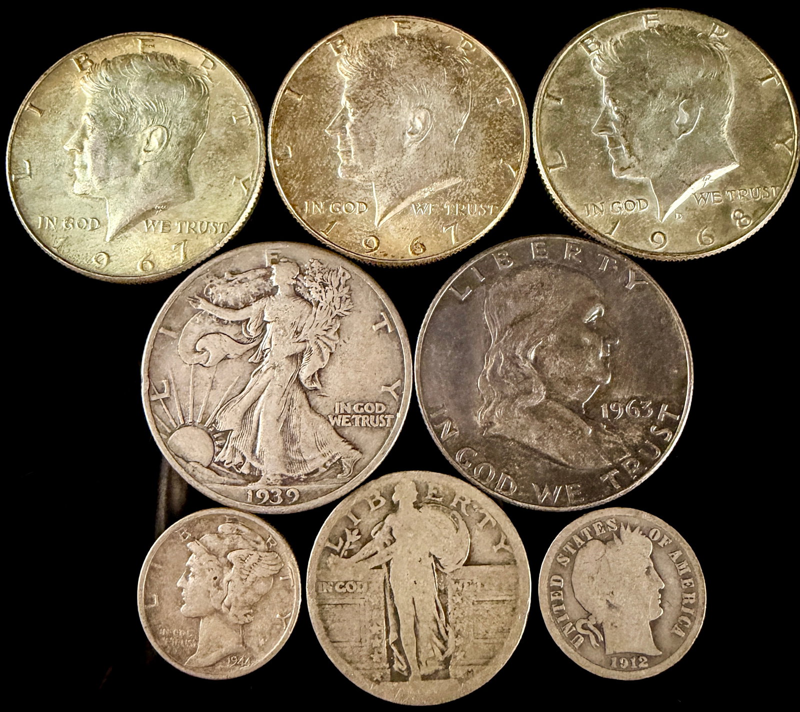 A Collection of Old United States Silver Coins: A collection of United States silver-composition coinage. The assortment includes Kennedy half dollars dated 1967 and 1968, a Walking Liberty half dollar dated 1939, and a Franklin half dollar dated 1