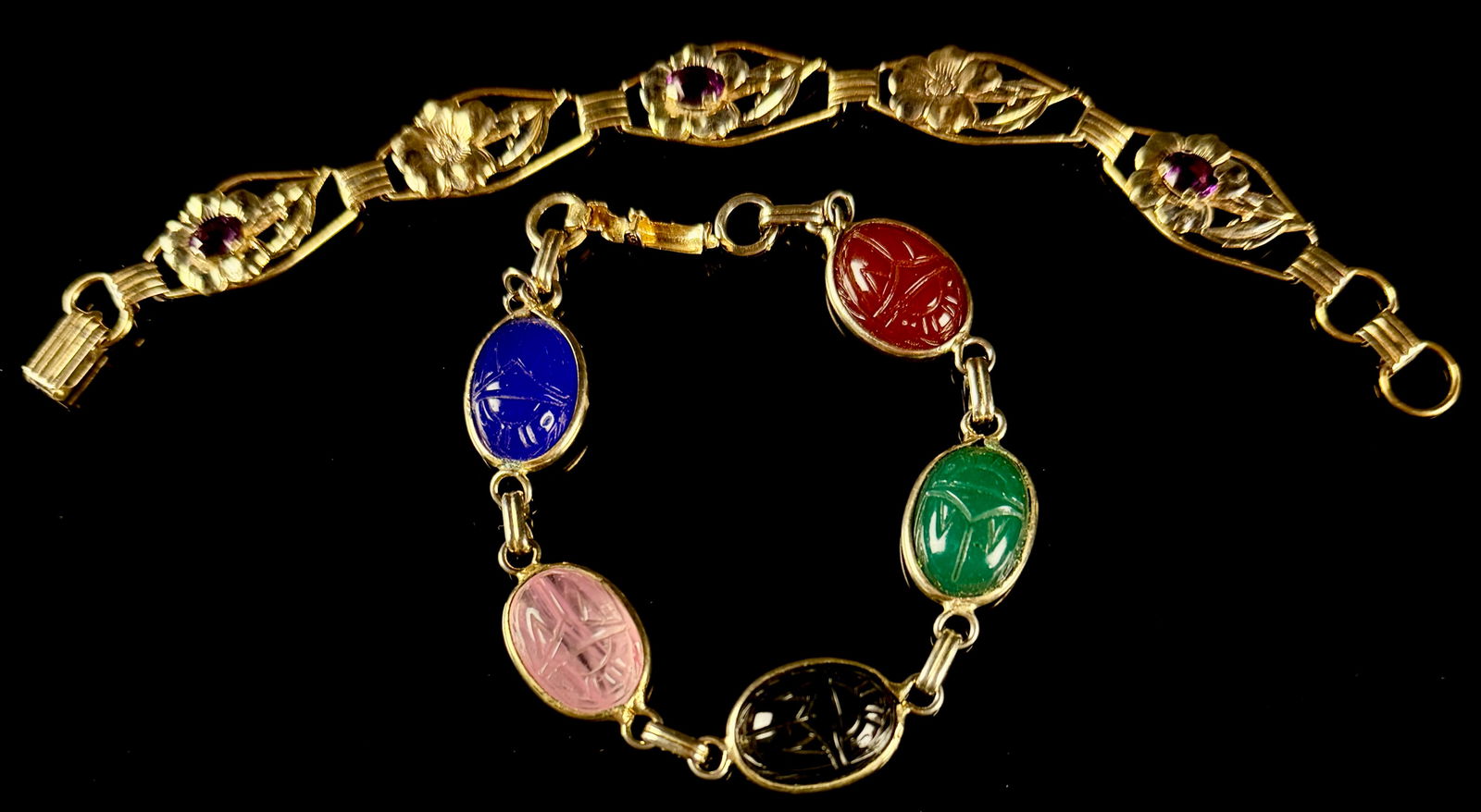 Two Vintage Bracelets Including a Coro Egyptian Scarab Beetle and a Providence Stock Co. Floral Link: This lot features two vintage bracelets of mid-century design. The first is a Coro Egyptian scarab beetle bracelet featuring five oval molded art glass cabochons in blue, pink, black, green, and red.