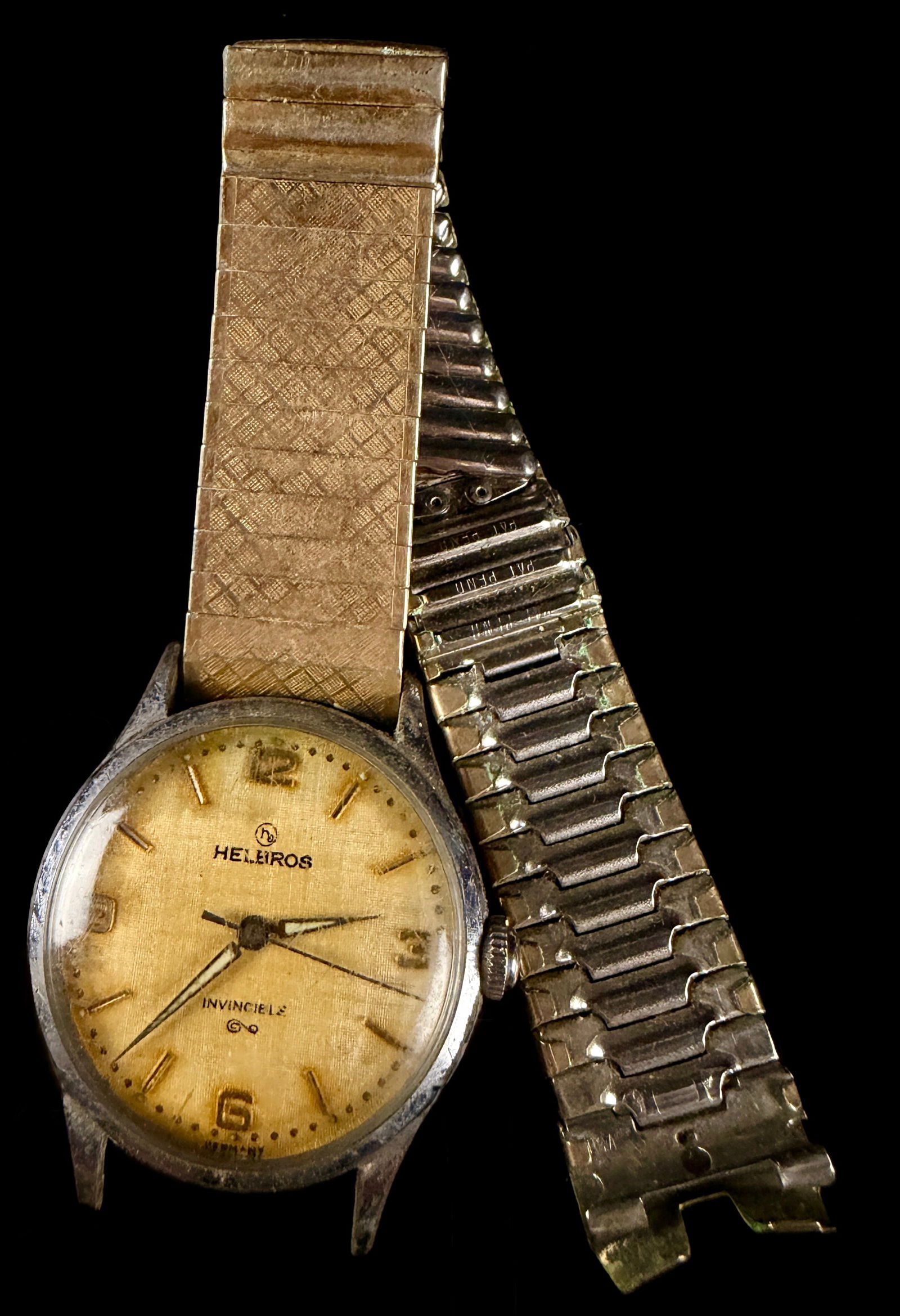 Helbros Invincible Wristwatch: Does not run, This Helbros Invincible wristwatch features a round metal case with a stainless steel screw-down back. The champagne-colored dial has a textured finish and is marked with the Helbros log