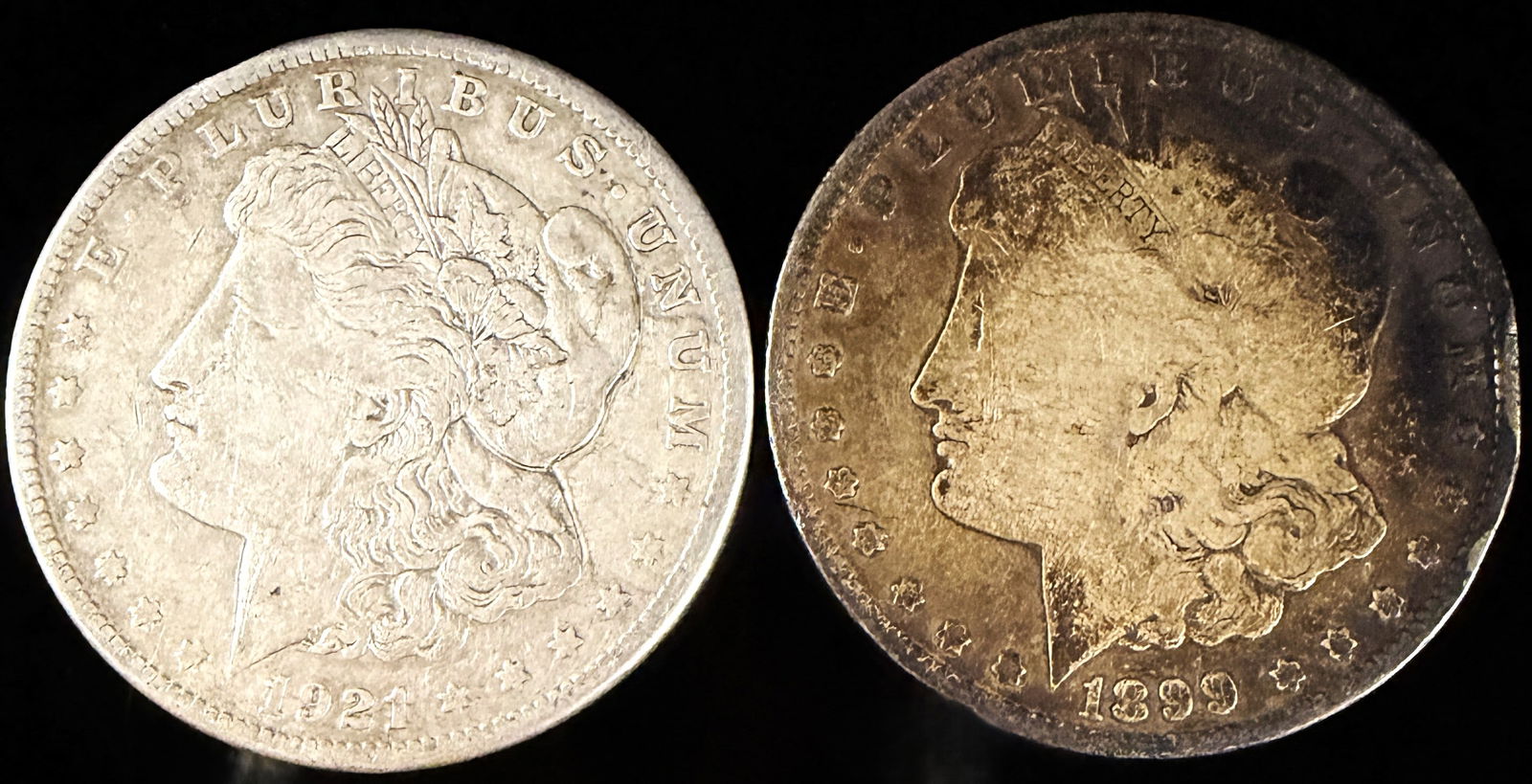 A Pair of Morgan Silver Dollars: A pair of United States Morgan silver dollars struck in silver . The group includes one specimen dated 1899 with an O mint mark for the New Orleans Mint and one specimen dated 1921 with an S mint