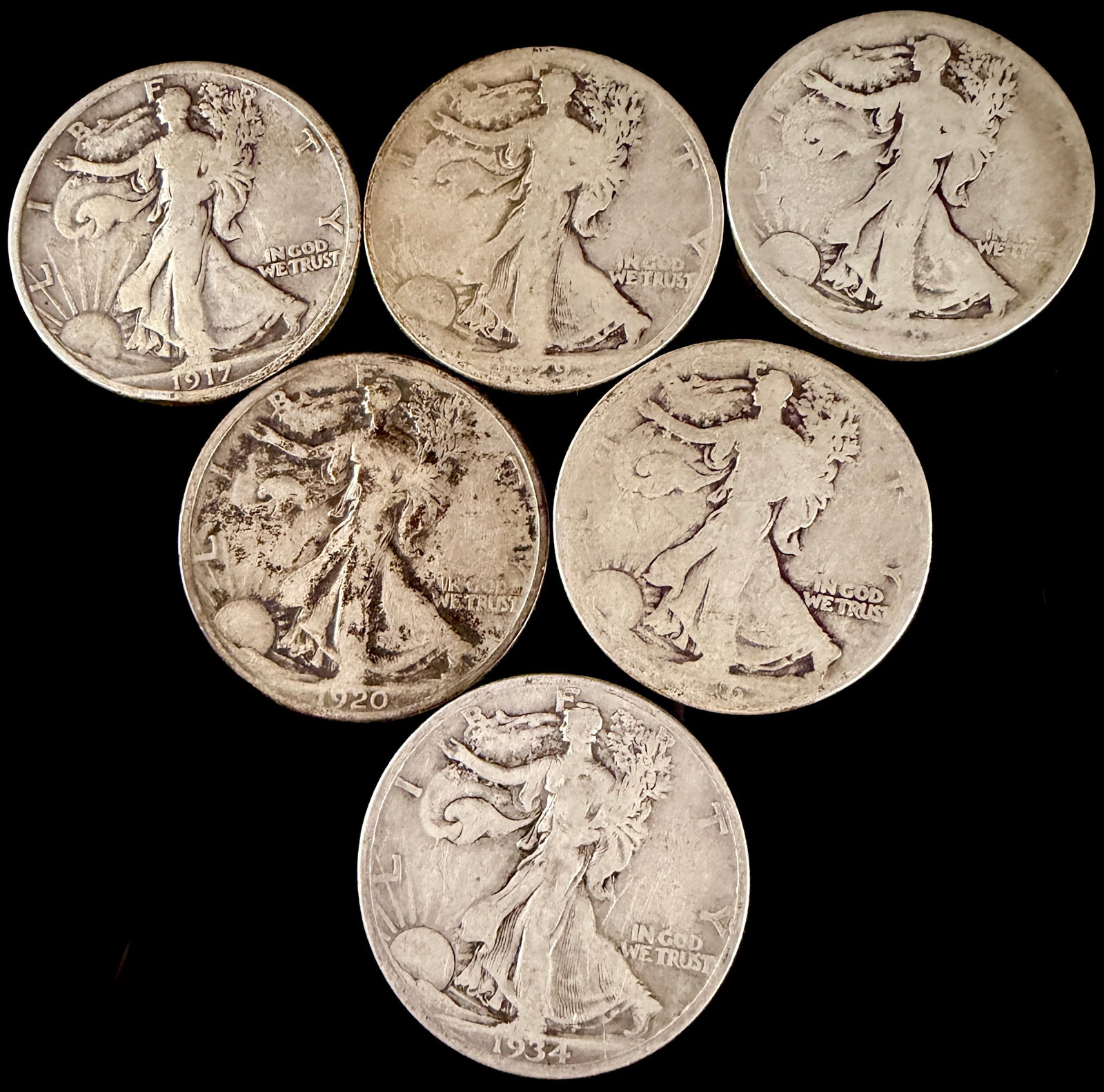 An Assortment of United States Walking Liberty Silver Half Dollars: An assortment of United States Walking Liberty silver half-dollar coins. The obverse of each coin features the figure of Lady Liberty walking toward a rising sun, draped in the American flag, with