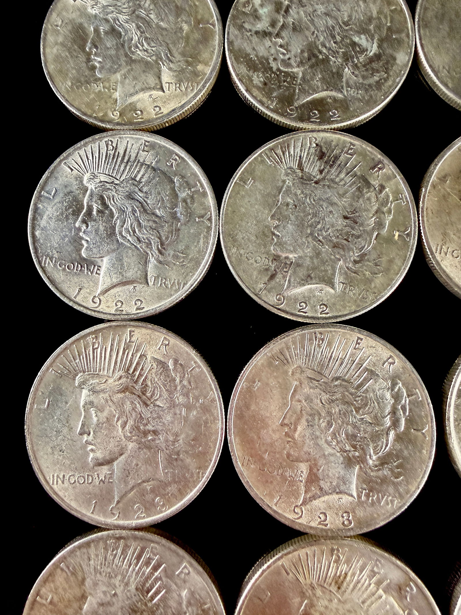 A Group of 20 United States Peace Silver Dollars: A group of United States Peace Silver Dollars struck in .900 fine silver. The collection features coins with visible dates including 1922, 1923, 1924, and 1925. Each coin displays the obverse design o