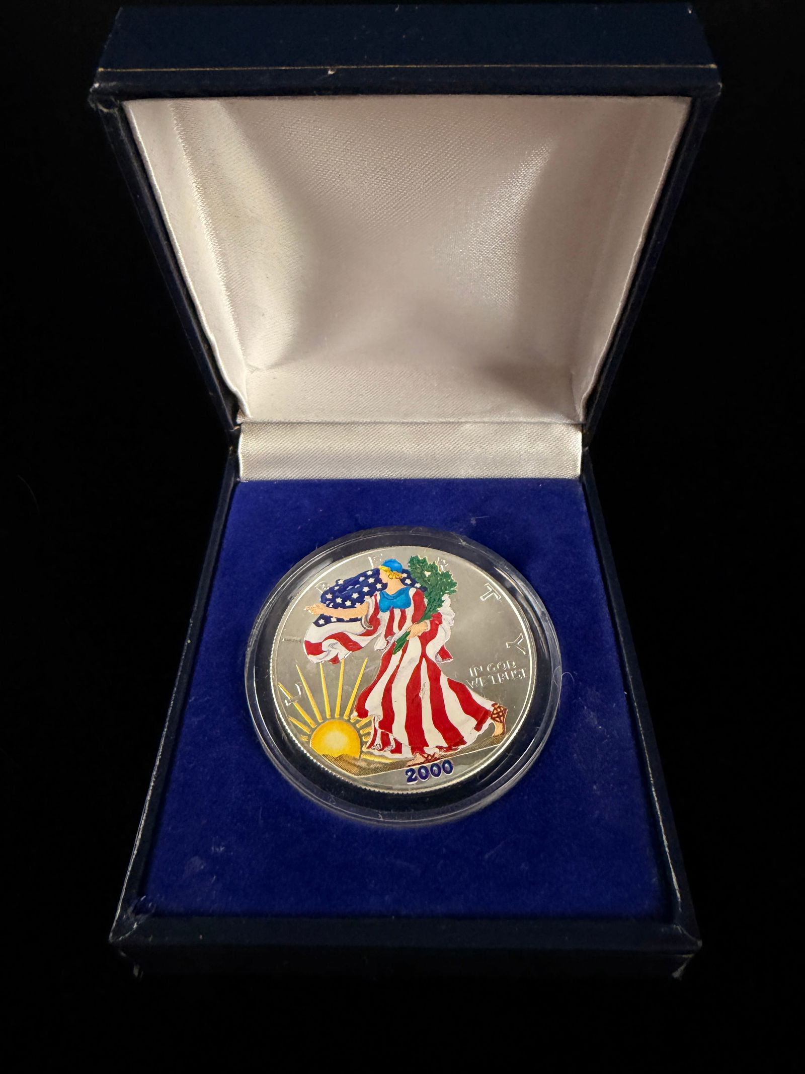 2000 Colorized American Silver Eagle 1 oz Silver Dollar: A 2000 United States American Eagle 1 oz silver bullion coin featuring a selectively colorized obverse. The Walking Liberty design is accented with red, white, and blue on the gown, green on the laure