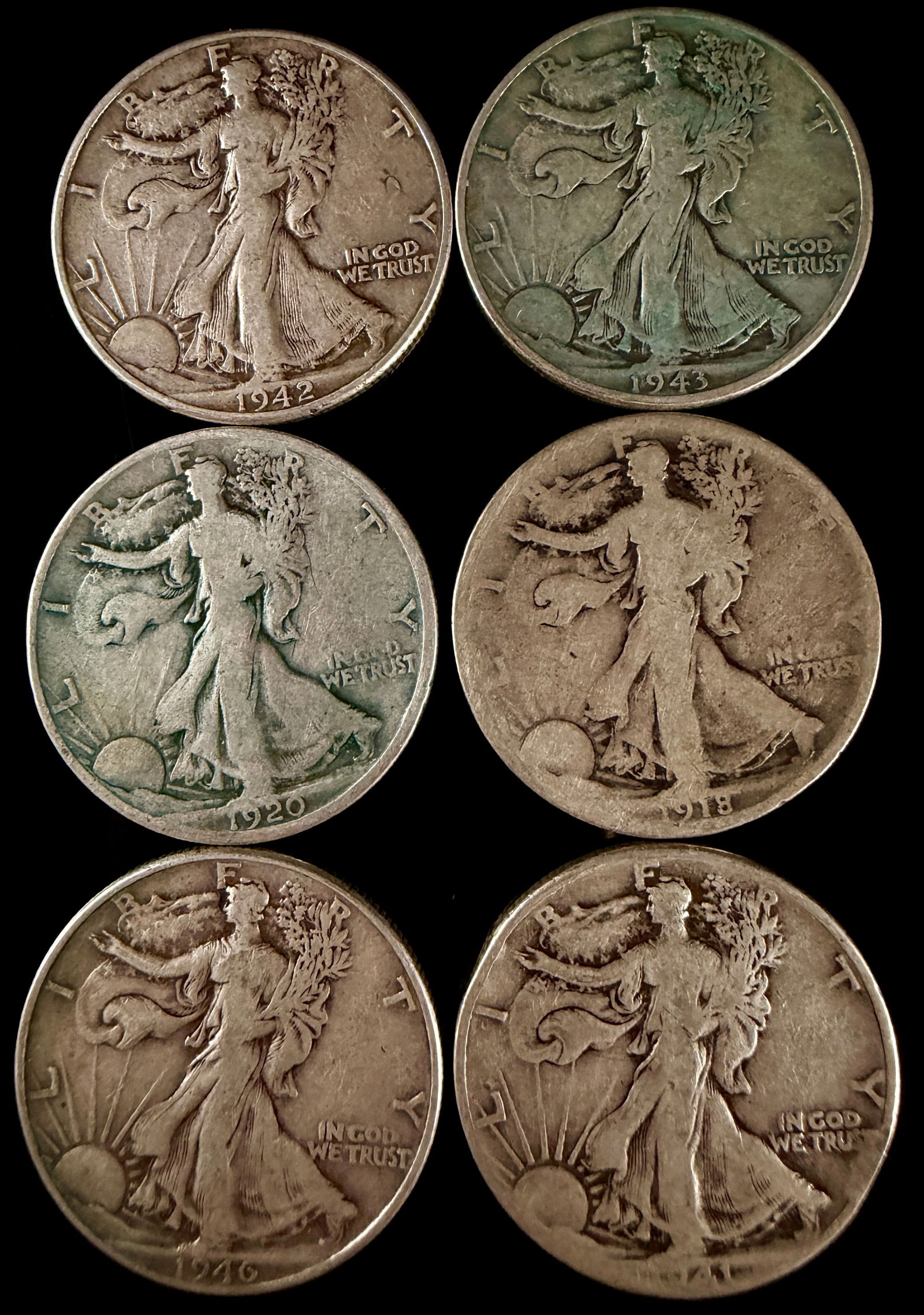 A Collection of Walking Liberty Silver Half Dollars: A collection of United States silver Walking Liberty half dollars featuring the design by Adolph A. Weinman. Each coin depicts a full-length figure of Liberty walking toward a rising sun on the obvers