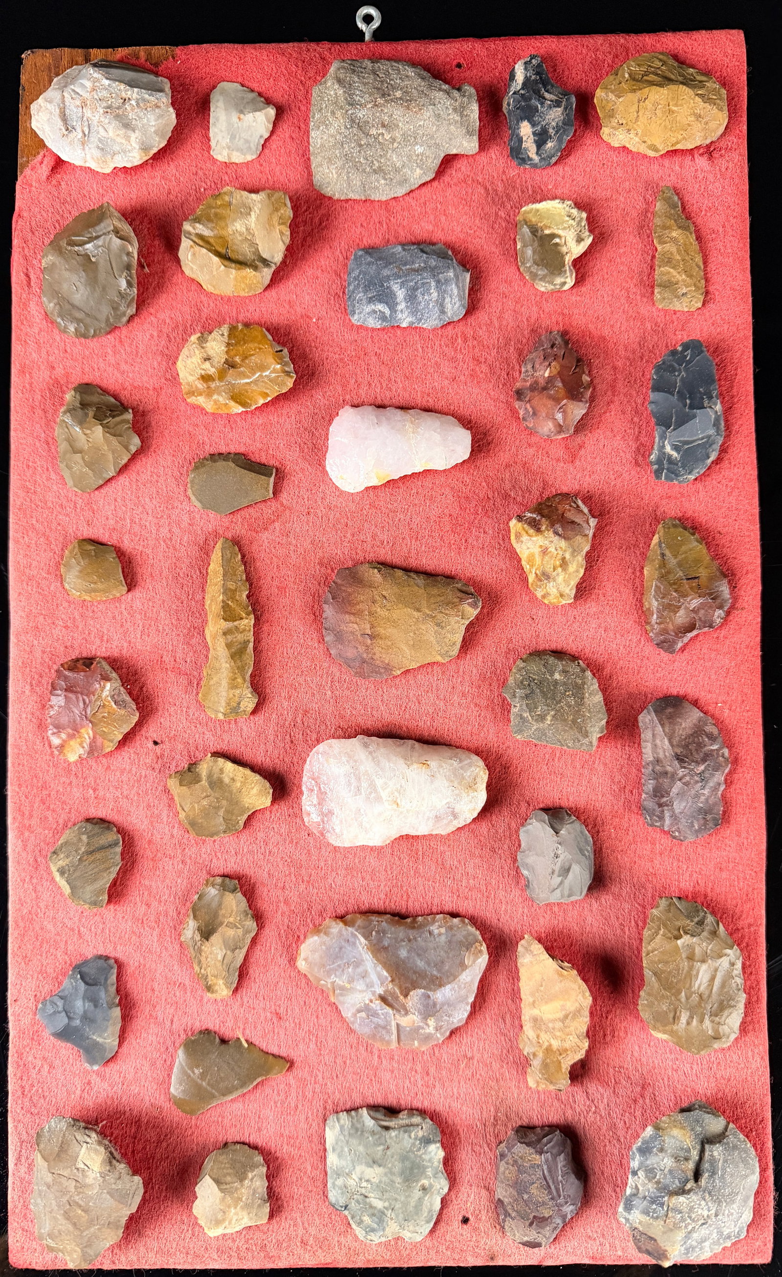 A Collection of Lithic Artifacts and Projectile Points: A collection of various lithic artifacts including projectile points, scrapers, and bifaces. The tools are crafted from diverse stone materials such as chert, flint, and quartz, exhibiting a range of