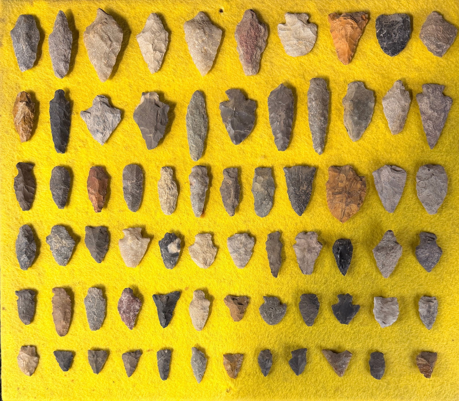 A Collection of Native American Stone Projectile Points: A collection of Native American stone projectile points and lithic tools fashioned from a variety of materials including chert, flint, and quartz. The assortment features various morphologies such as