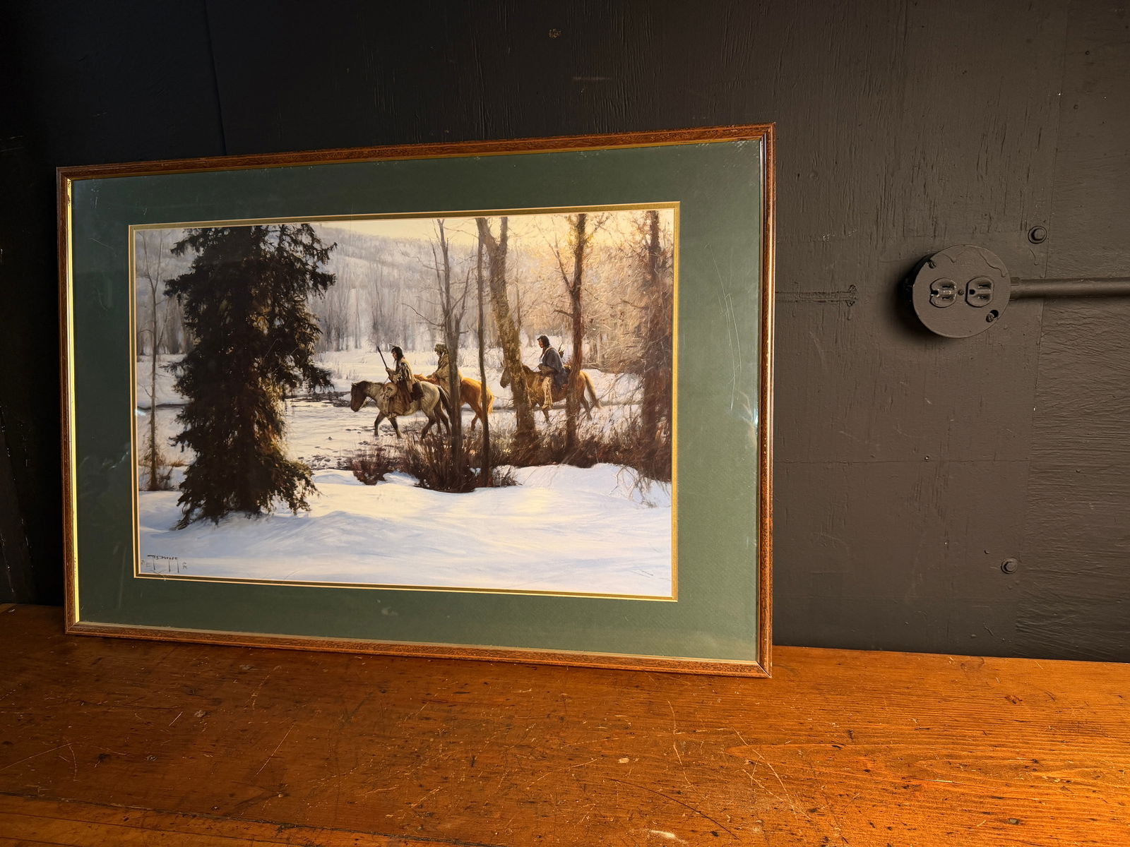 Following the River by Robert Duncan Framed Art Print: A framed Western art print titled Following the River by Robert Duncan. The scene depicts three Native American riders on horseback traveling through a snow-covered, wooded landscape during dawn or