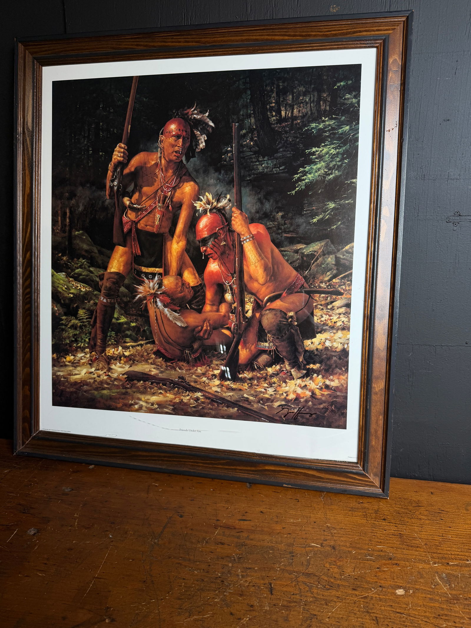 Robert Griffing Friends Under Fire Limited Edition Signed Print: This limited edition print is titled Friends Under Fire by artist Robert Griffing. The artwork depicts a group of Native American warriors with muskets in a historical forest setting. The piece is han