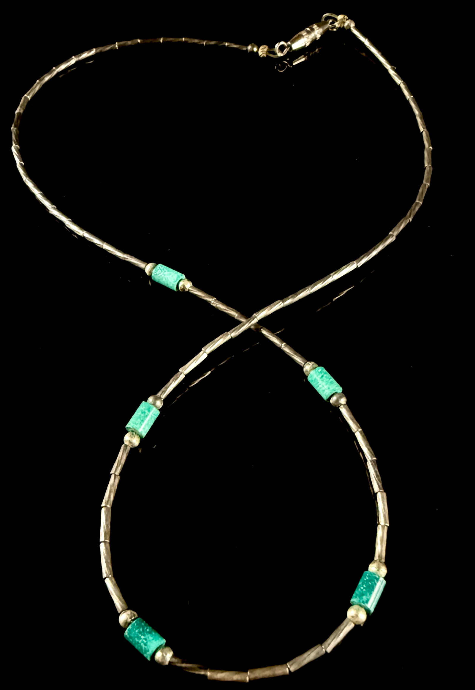 Southwest Style Liquid Silver and Turquoise Bead Necklace: This necklace is designed in the Southwest Native American style, featuring a liquid silver chain. The strand consists of multiple fine, tubular silver-tone metal beads interspersed with small round m