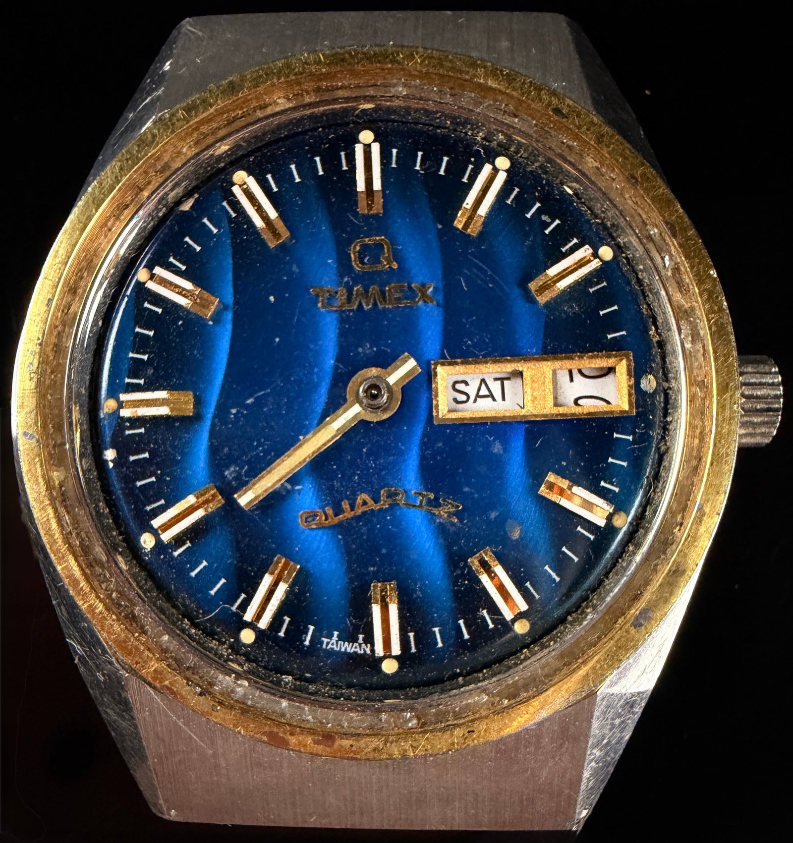 Vintage Q Timex Falcon Eye Quartz Wristwatch with Blue Wavy Dial: This is a vintage Q Timex Falcon Eye wristwatch head. Untested Missing the crystal, second and minute hand. The timepiece features a stainless steel case with a gold-toned bezel. The blue dial is deco