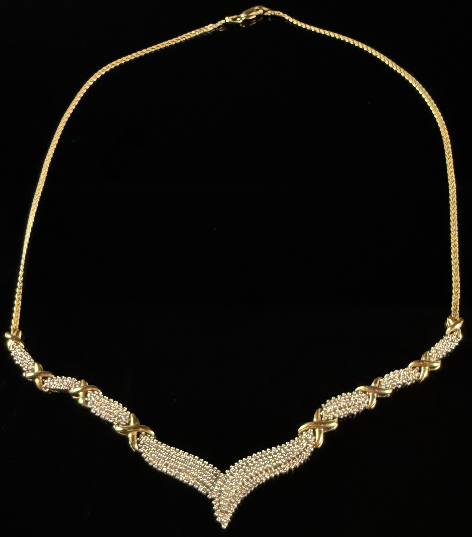 Two-Tone Sterling Silver and Clear Stone Chevron Necklace, SUN: A two-tone sterling silver necklace featuring a decorative chevron or V-shaped front. The central design is composed of a primary V-shaped element flanked by four articulated segments on each side. Ea