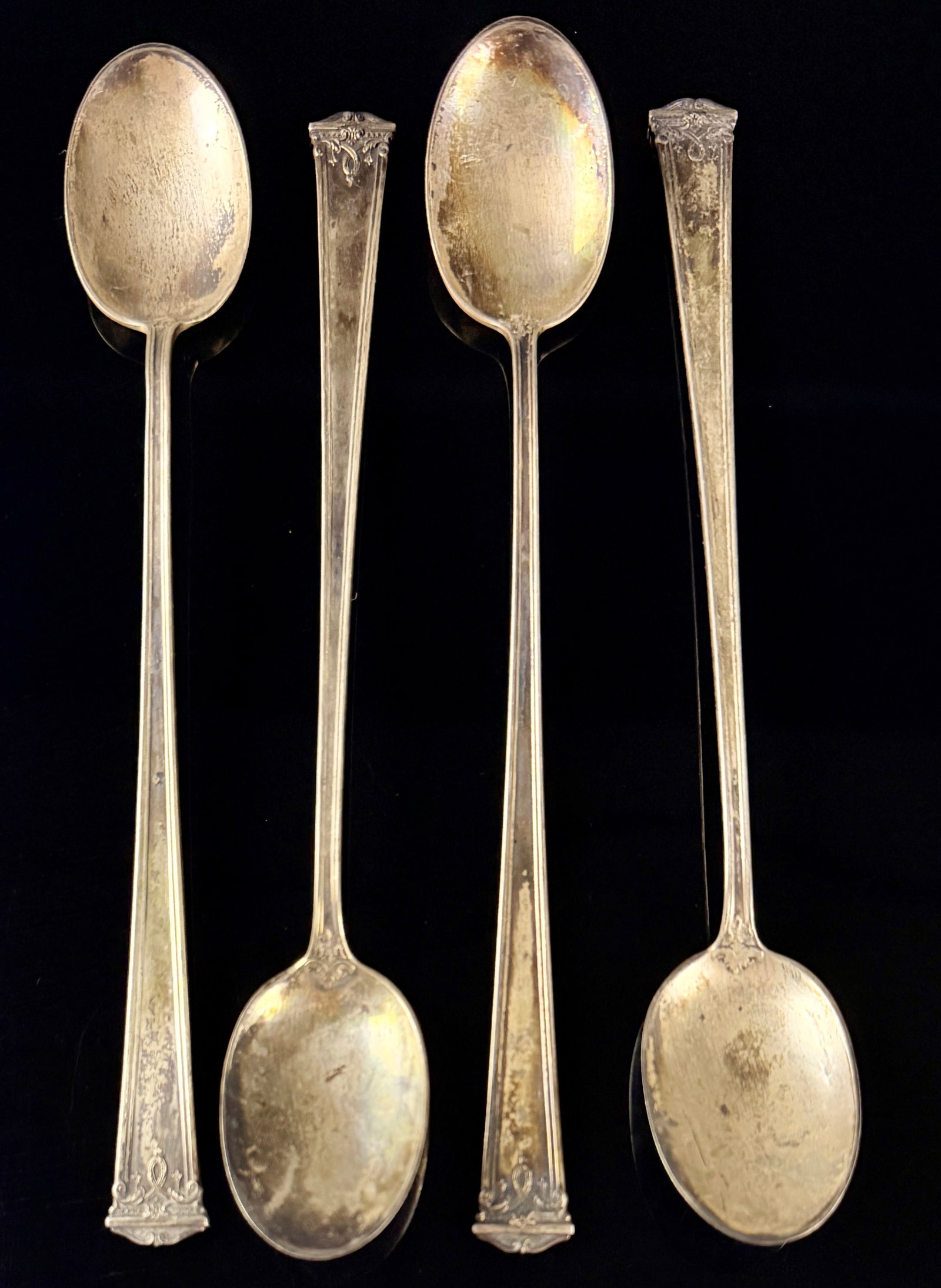 A Set of Four Heirloom Sterling Company Sheraton Pattern Sterling Silver Iced Tea Spoons: A set of four American sterling silver iced tea spoons in the Sheraton pattern by the Heirloom Sterling Company, a division of Oneida Community, Ltd. The pattern, patented in 1913, features a Neo-Clas