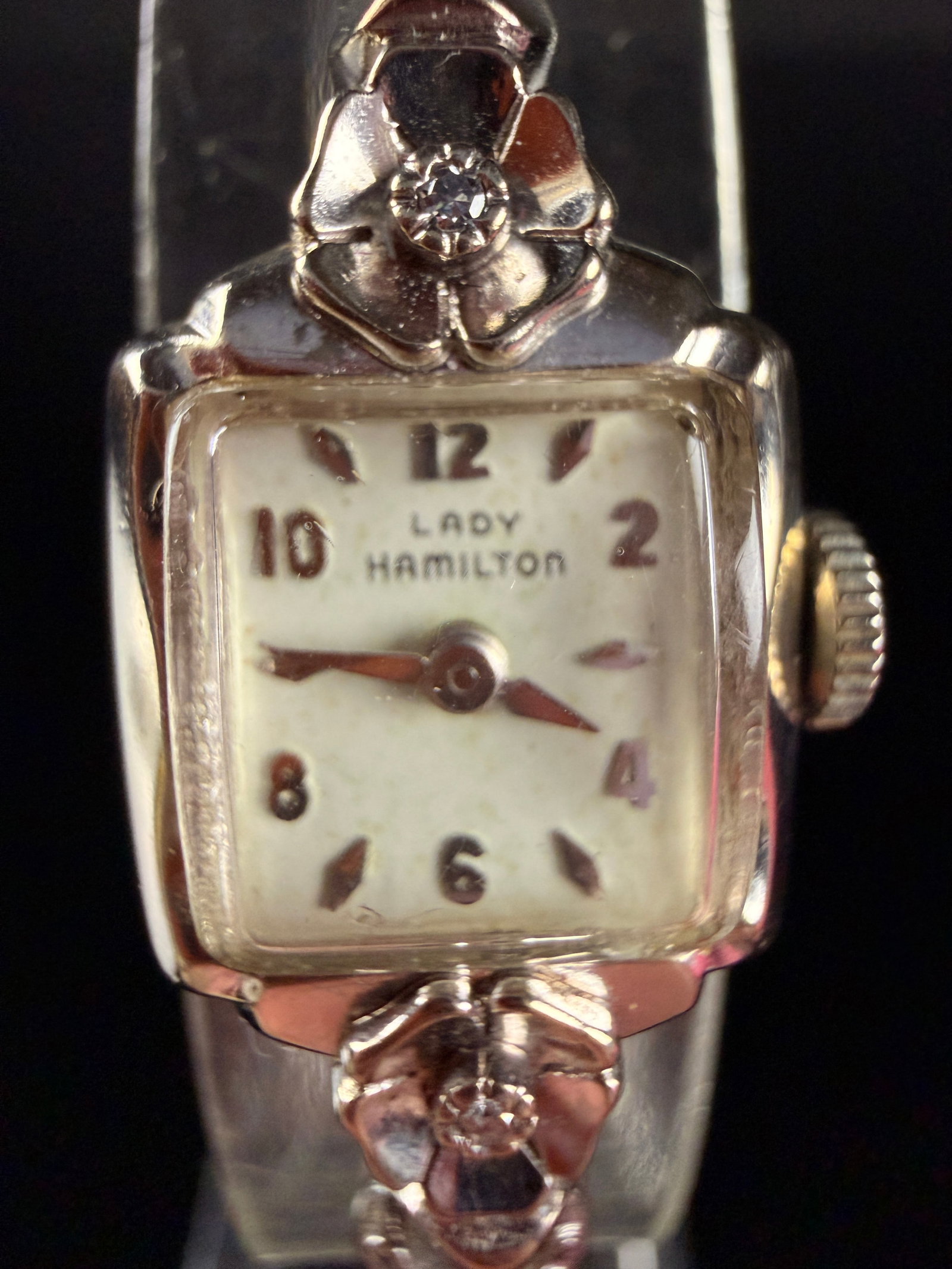 Vintage Lady Hamilton 14K White Gold Manual Wind Wristwatch with Diamond Accents: A vintage Lady Hamilton manual wind wristwatch featuring a 14 karat white gold case manufactured by Biggs. The square cushion-shaped case is designed with decorative floral-motif lugs, each set with a