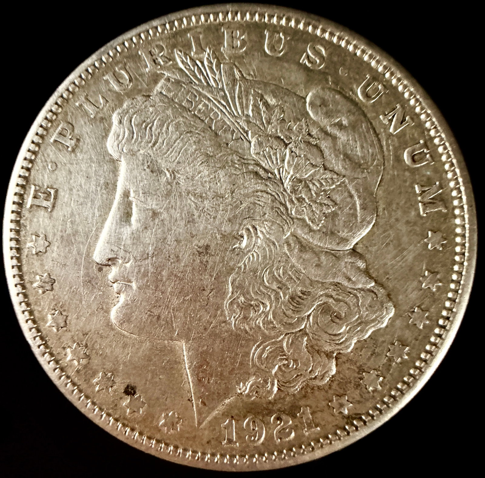 1921 US Morgan Silver Dollar: 1921 US Morgan silver dollar, Philadelphia mint. This coin is struck in a silver composition and features the Morgan design on both the obverse and reverse. The obverse displays the date 1921 and the