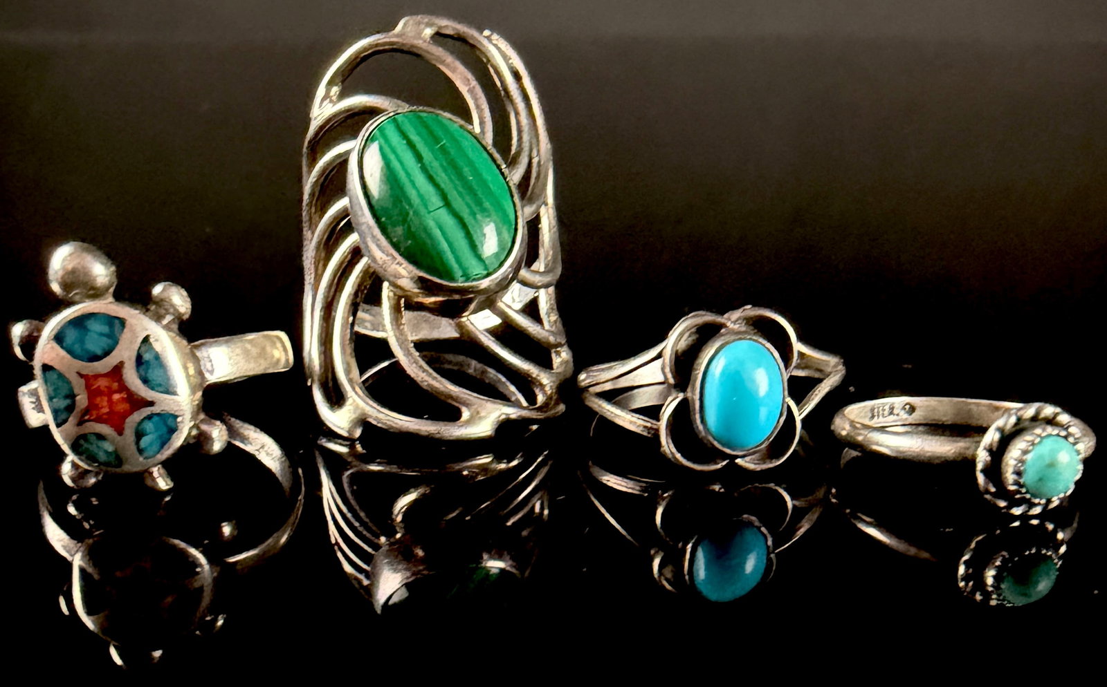 An Assortment of Southwest Style Silver and Sterling Silver Gemstone Rings: An assortment of four rings in the Southwest and Native American style, including designs attributed to Navajo and Zuni traditions. The collection includes a turtle-motif ring featuring a multi-stone