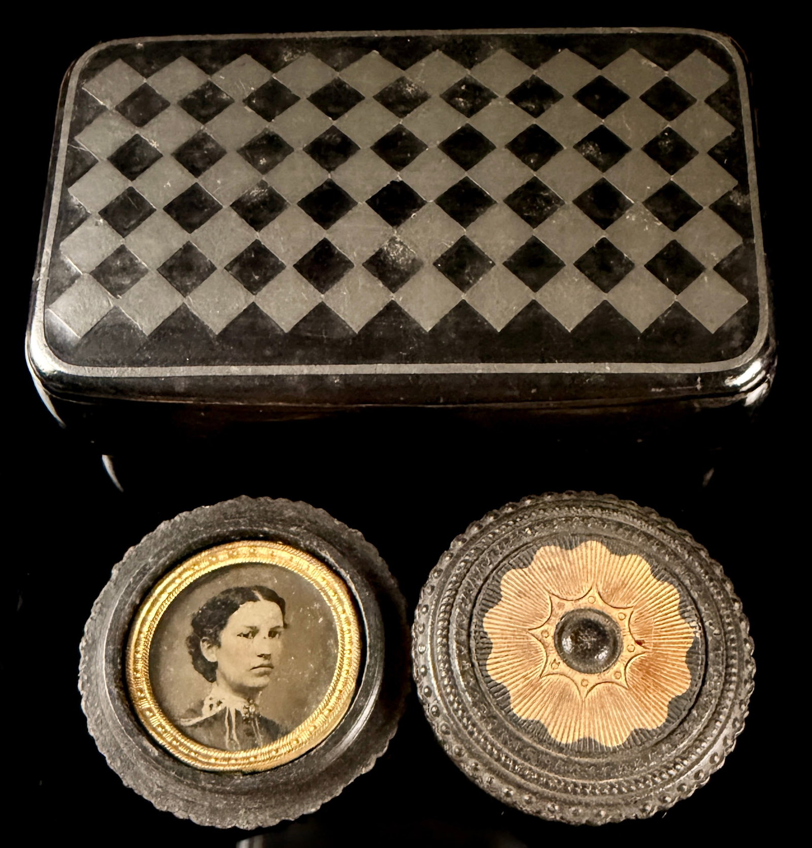 Two Victorian Personal Items Including a Checkerboard Inlaid Box and a Tinted Portrait in: This lot consists of a rectangular lidded box and a circular photograph case, both dating to the mid-to-late 19th century. The rectangular box is constructed from a dark material, likely horn or lacqu