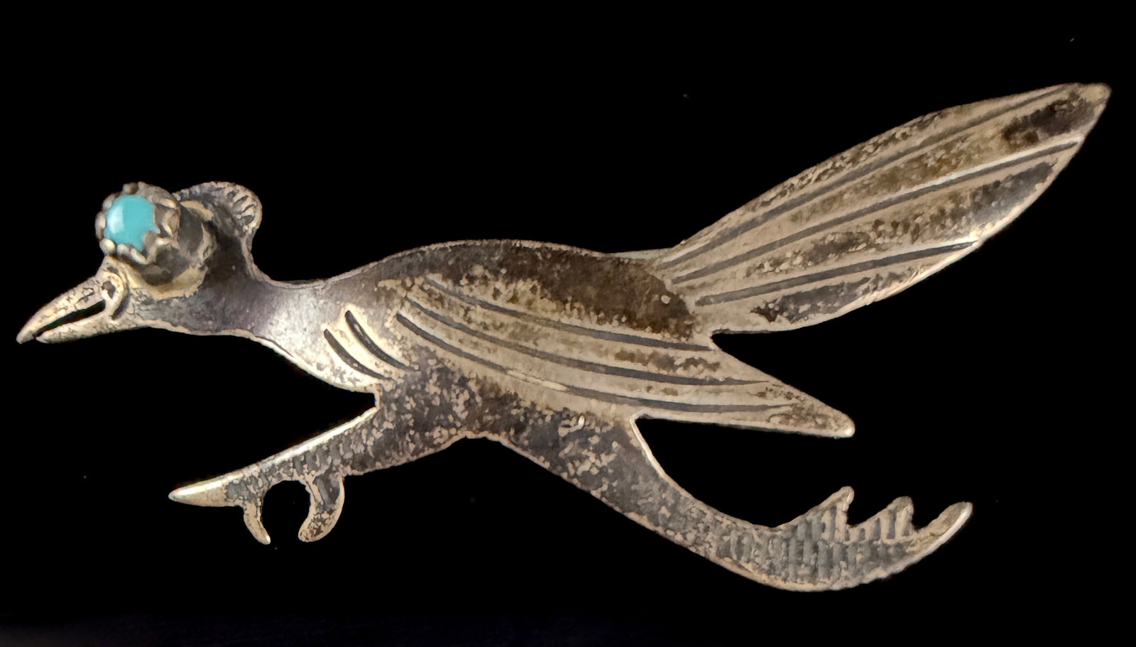 Vintage Navajo Style Silver and Turquoise Roadrunner Brooch: A vintage silver brooch designed in the form of a roadrunner in a running pose, attributed to Navajo or Southwestern regional craftsmanship. The body and tail feature stylized incised lines to represe