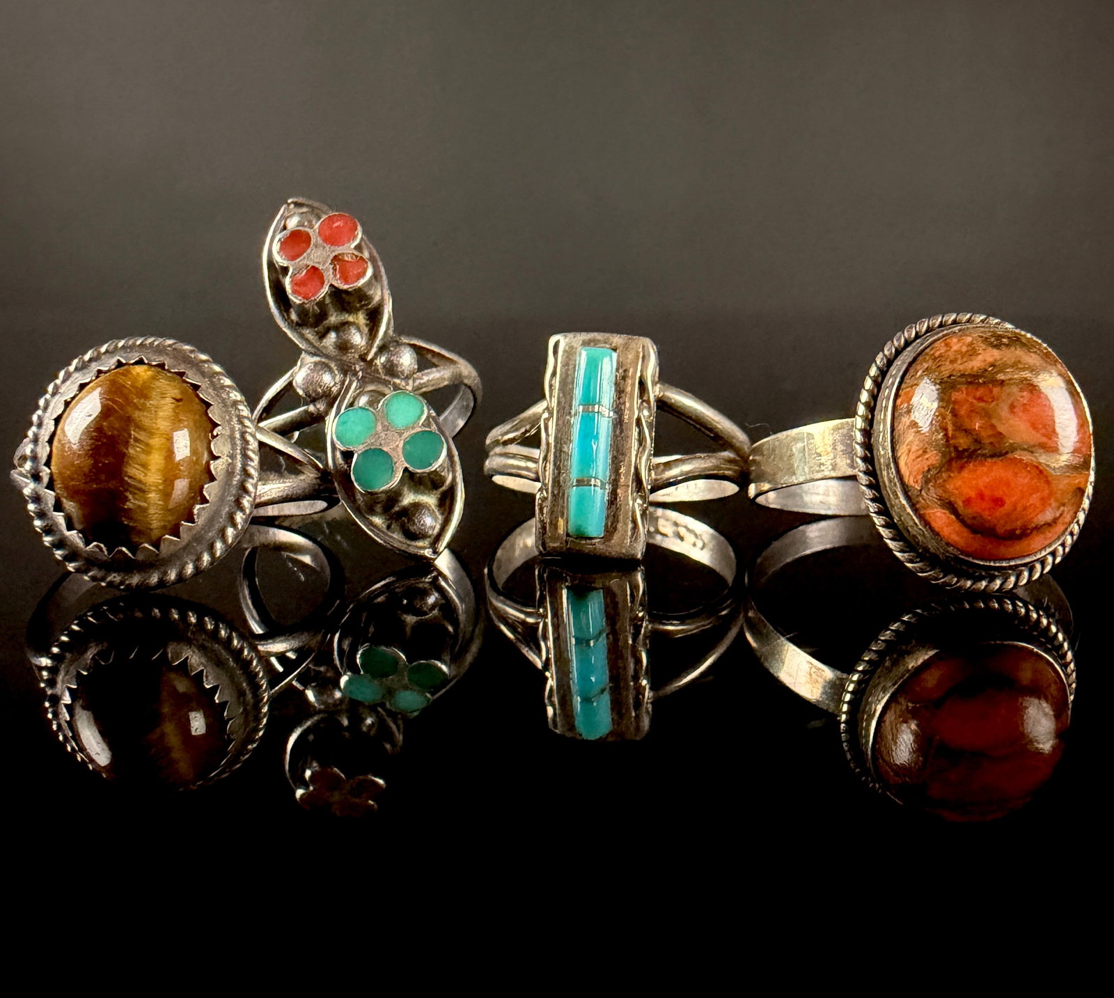 A Collection of Southwestern Sterling Silver and Gemstone Rings: This collection consists of Southwestern-style rings crafted in sterling silver with various gemstone settings. One rectangular cocktail ring features three sections of turquoise channel inlay within
