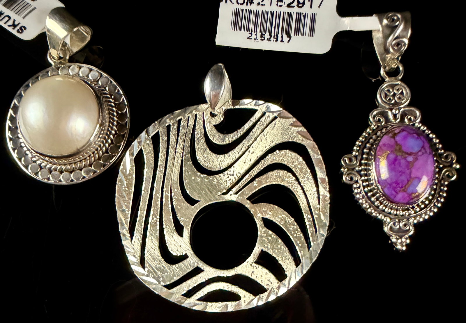 Sterling Silver Pendants Including Purple Mojave Turquoise and Mother of Pearl: This lot consists of sterling silver pendants of various styles and origins. The first pendant features an oval cabochon of purple Mojave turquoise composite with a prominent gold-toned matrix. The st