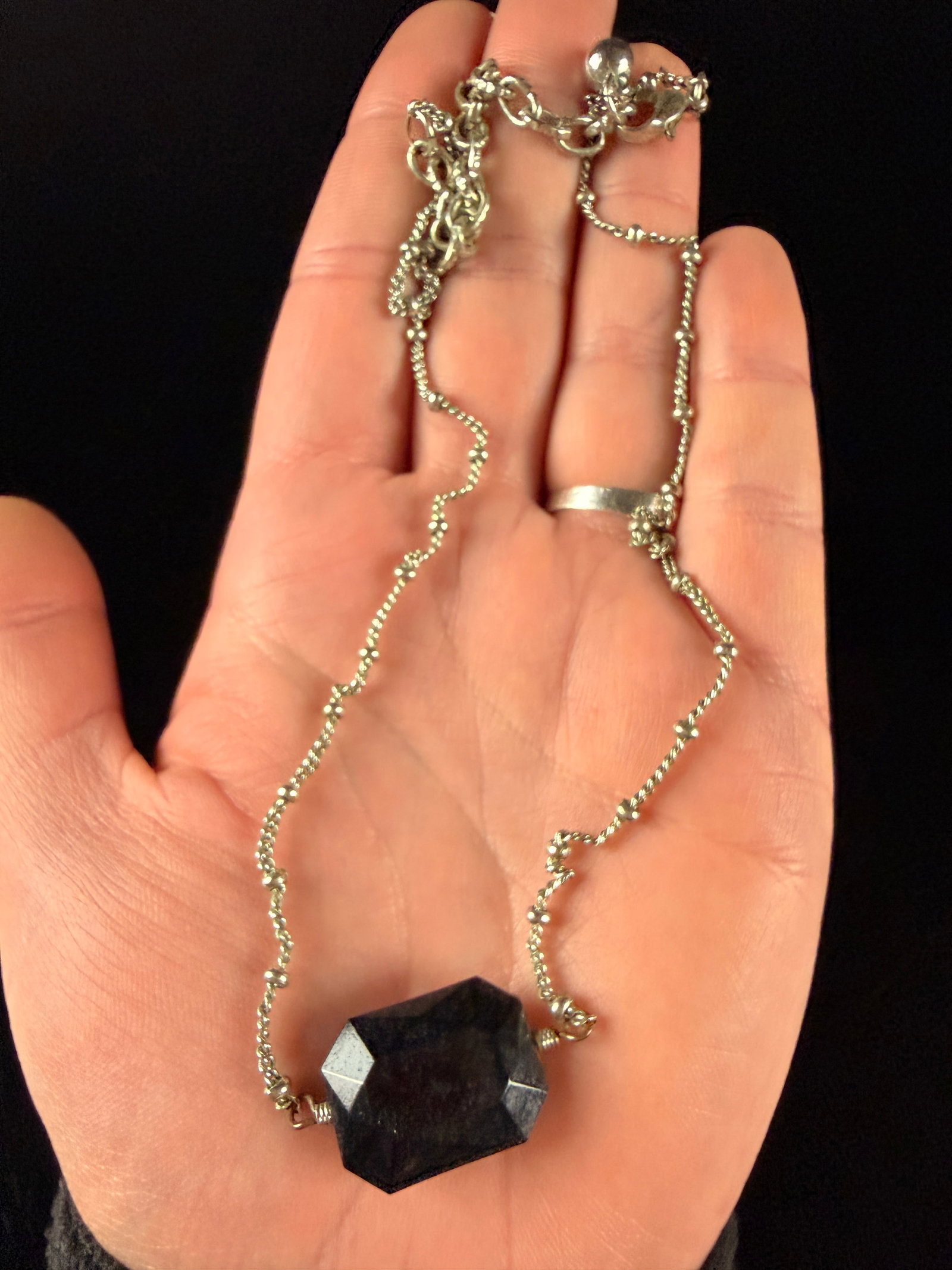 Silver-Toned Satellite Chain Necklace with Faceted Black Obsidian Style Pendant: This necklace features a single integrated focal point consisting of a large, faceted, opaque stone. The stone is rectangular with clipped corners in an emerald-cut style and exhibits a very dark navy