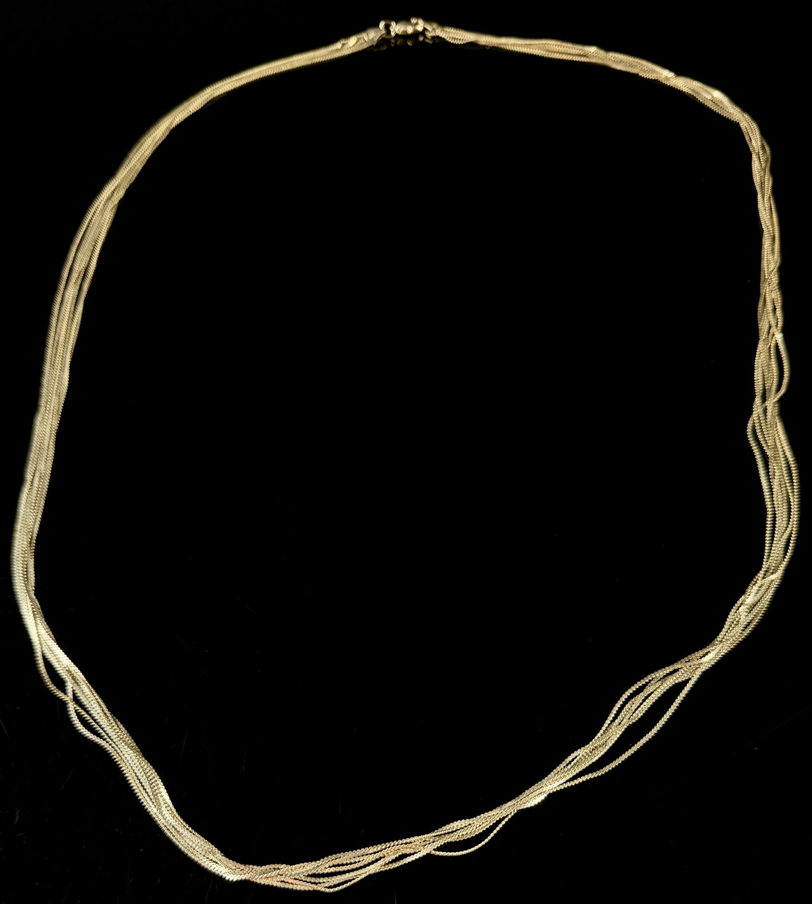 IBB Italian Sterling Silver Eight Strand Woven Mesh Necklace: This multi-strand necklace is constructed from sterling silver and features eight individual strands of fine woven mesh chain. The necklace is secured with a lobster claw clasp. The end-caps provide d