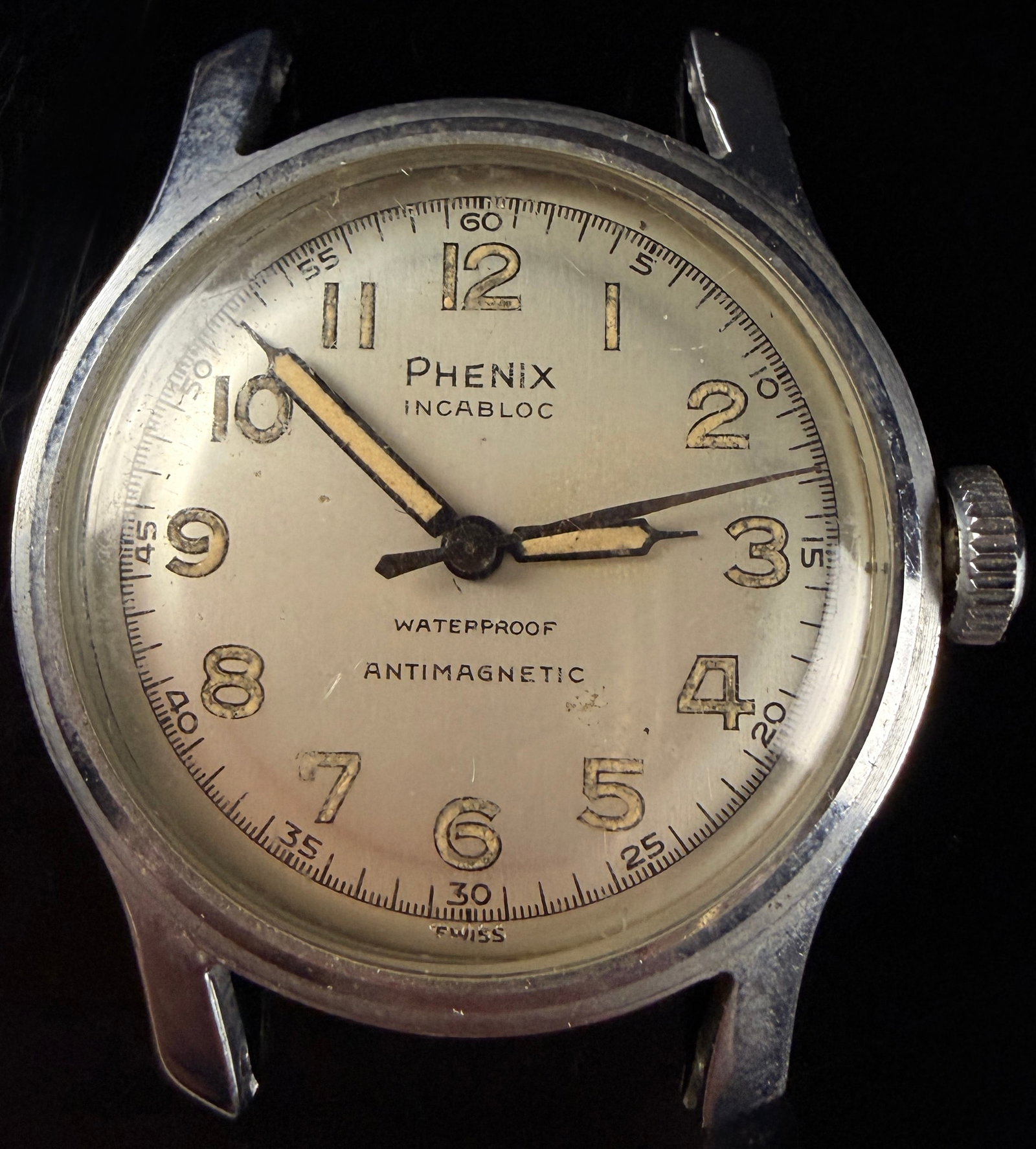 Vintage Phenix Incabloc Manual Wind Swiss Wristwatch: A mid-century Swiss-made manual wind field-style wristwatch by the Phenix Watch Company. The timepiece features a base metal case with chrome plating and a stainless steel screw-down back. The cream-c