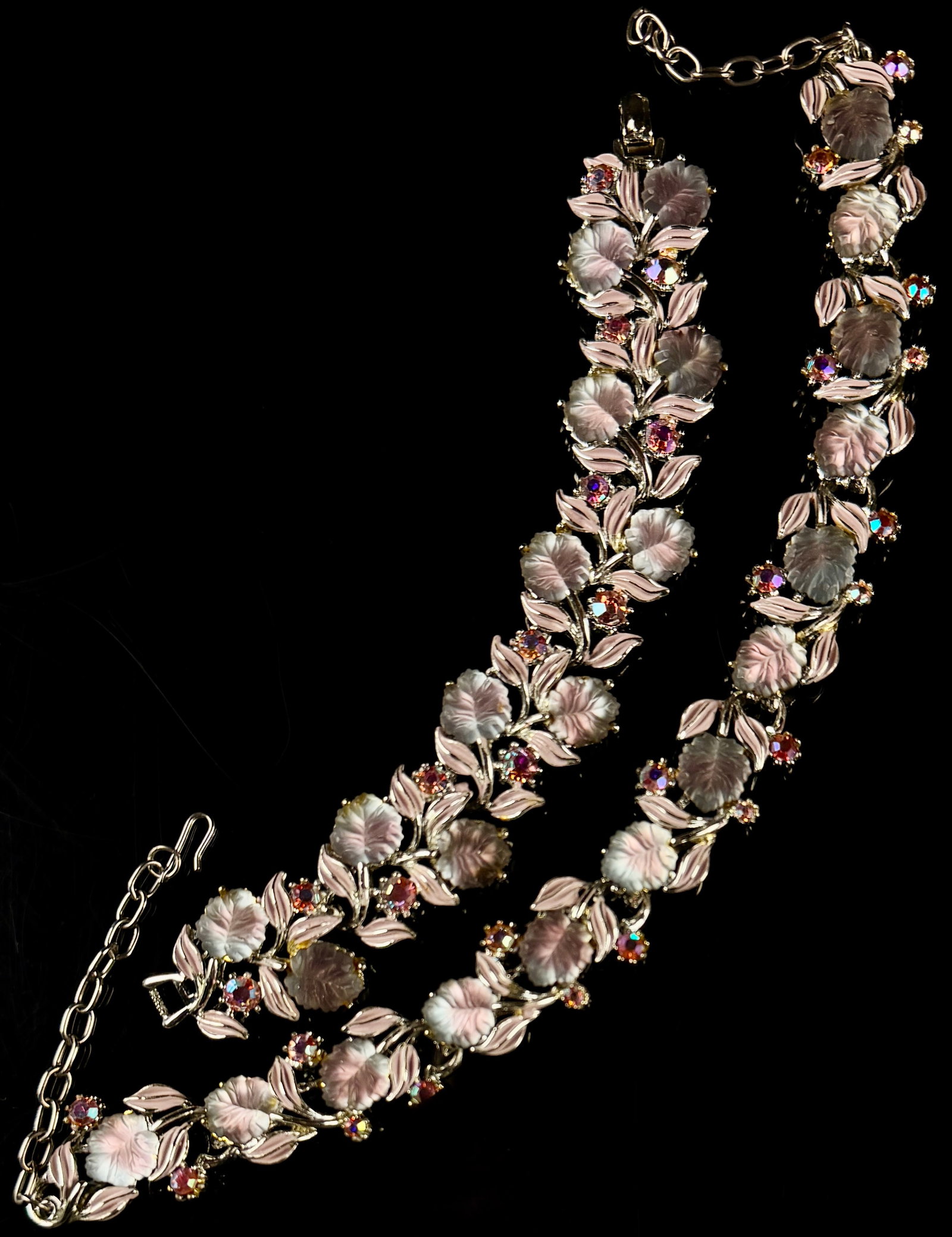A Pair of Mid-Century Costume Jewelry Items Featuring Frosted Glass Leaves and Aurora Borealis: This vintage costume jewelry demi-parure consists of a matching necklace and bracelet. Both items are constructed from gold-tone base metal and feature articulated links in a foliate pattern. The desi