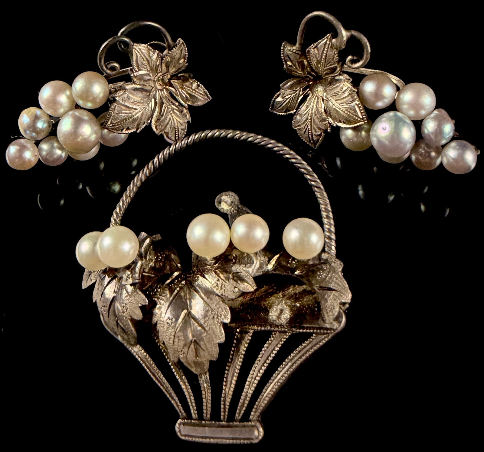 A Trio of Sterling Silver and Cultured Pearl Jewelry Pieces: This mid-century jewelry suite includes a brooch and a pair of matching earrings featuring botanical grapevine motifs. The brooch is designed as a basket with a twisted rope handle and textured leaves