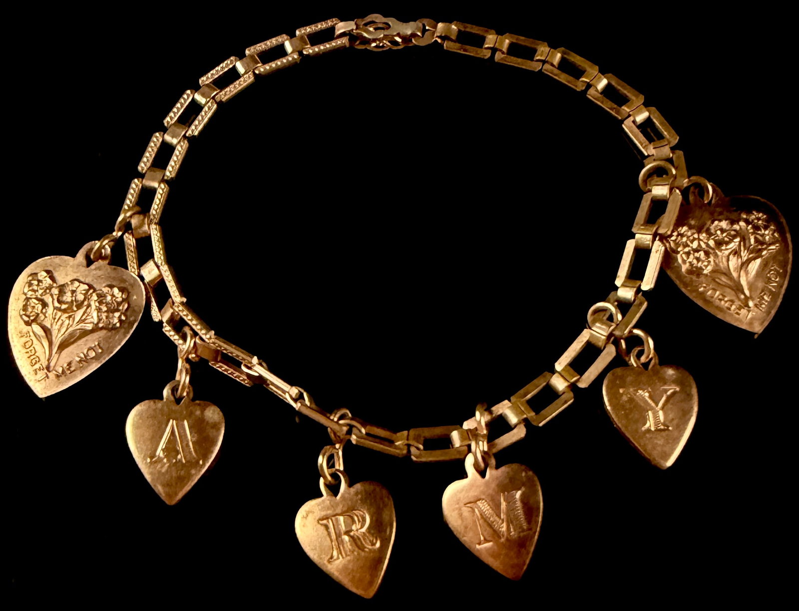 Vintage World War II Era Army Sweetheart Charm Bracelet: This vintage Army sweetheart charm bracelet is composed of yellow gold-tone metal. The chain features textured rectangular open links with milgrain borders and a central filigree link decorated with s
