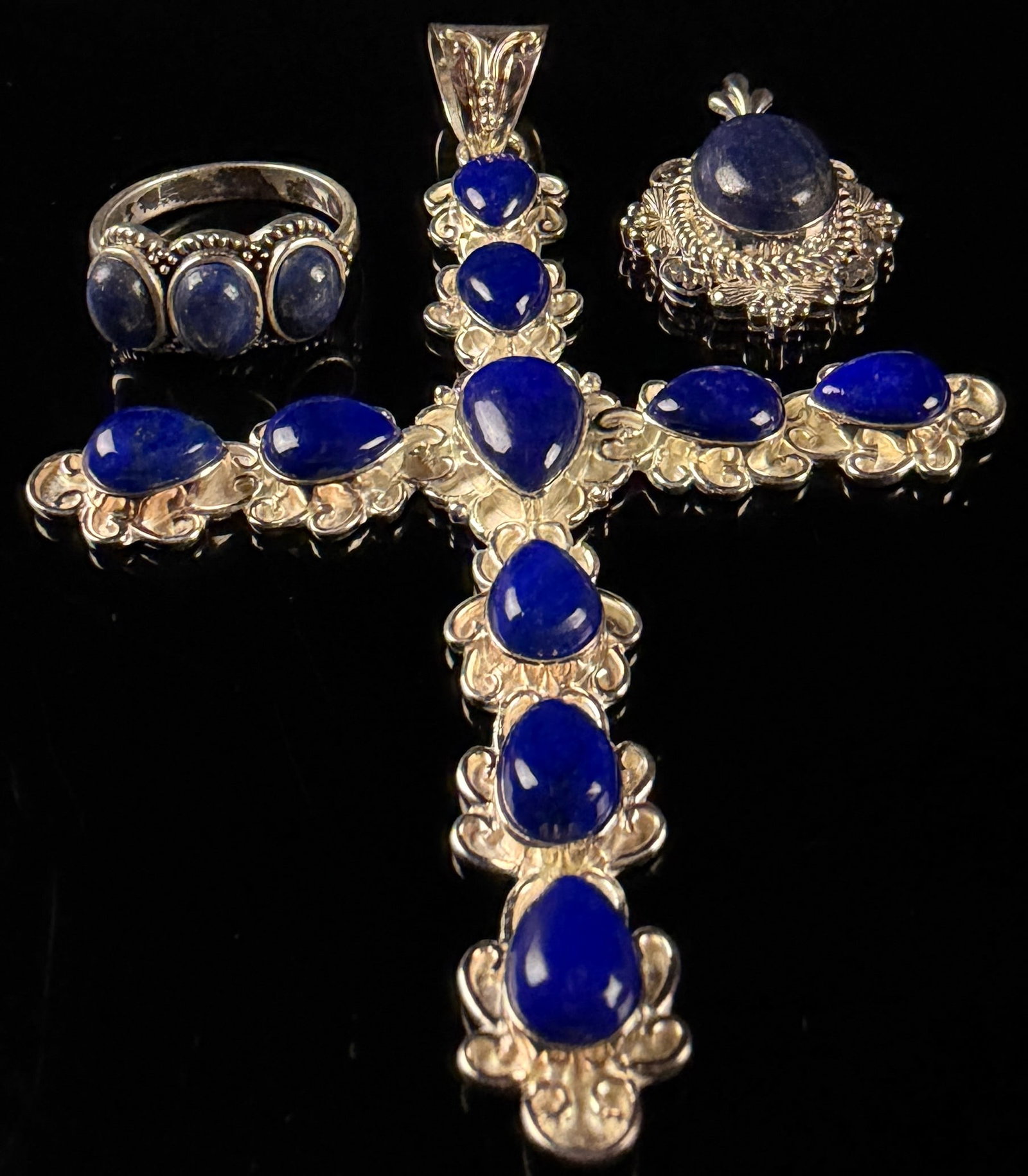 A Trio of Large Sterling Silver and Lapis Lazuli Jewelry Pieces: This set consists of three jewelry items featuring large components and cabochons that appear to be lapis lazuli. The gemstones exhibit a deep blue color with visible golden pyrite inclusions. The col