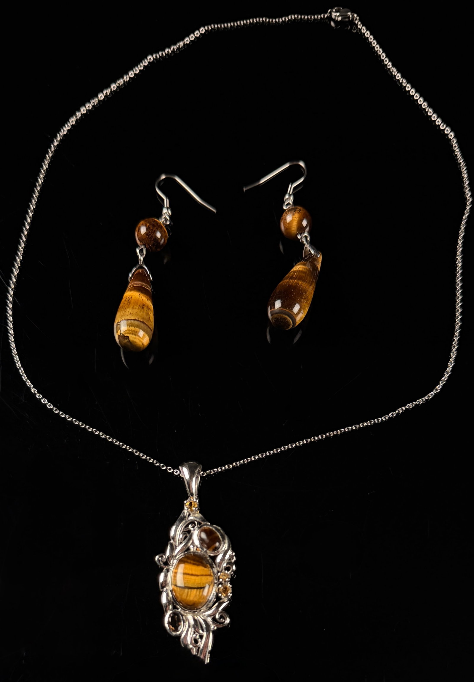 Karis Tiger's Eye and 925 Sterling Silver Art Nouveau Style Pendant Necklace and Earrings Jewelry: A three-piece jewelry set from the maker Karis, consisting of a pendant necklace and matching drop earrings. The pendant features an Art Nouveau-inspired openwork frame with scrolled floral motifs, ho