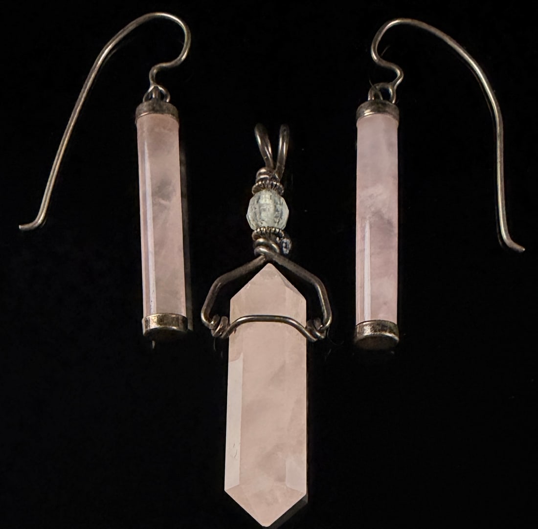 A Trio of Rose Quartz and Silver-Toned Metal Artisan Jewelry: An artisan three-piece jewelry set consisting of a pendant and a matching pair of earrings. The pieces are crafted from polished rose quartz and silver-toned metal. Each earring features a cylindrical