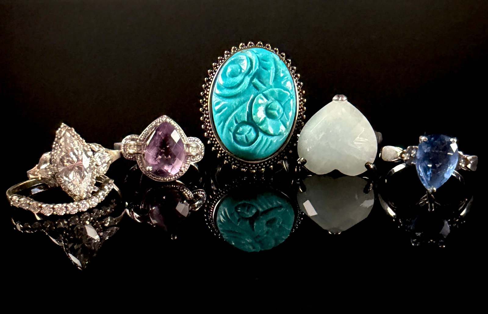 A Collection of Sterling Silver and Gemstone Cocktail and Accent Rings: A collection of sterling silver and silver-tone jewelry comprising various cocktail and accent rings. The assortment includes a large statement ring featuring an oval turquoise-colored stone cabochon 