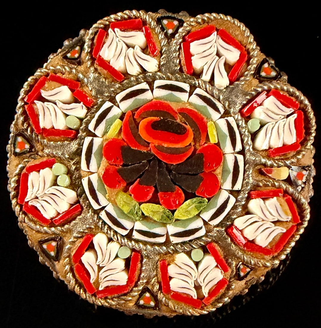 Italian Floral Micro-Mosaic Circular Brooch: A circular micro-mosaic brooch featuring a central rose motif in red and black. The central floral element is surrounded by a ring of eight white leaf-shaped or floral motifs, each framed by red